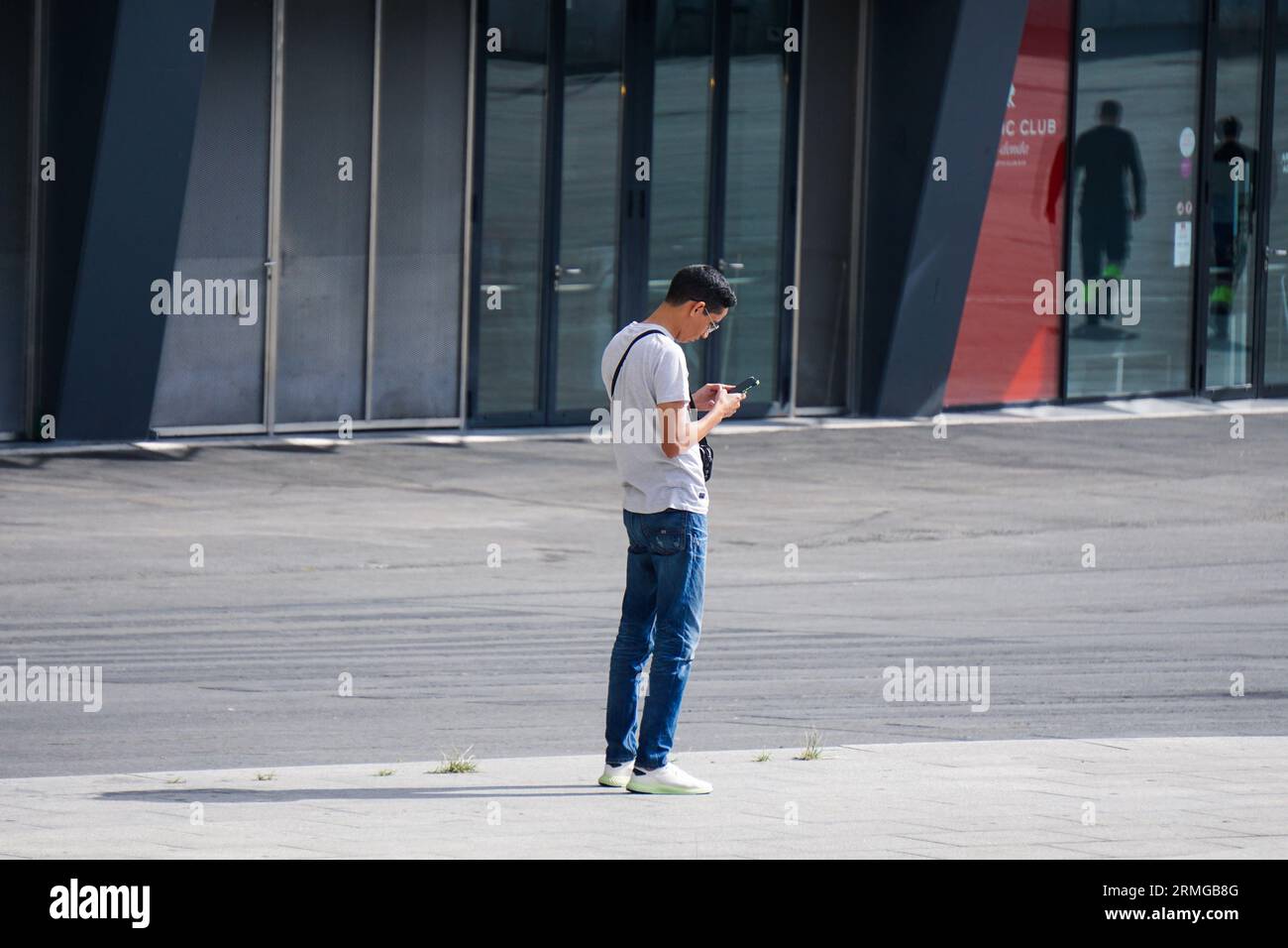 personne marchant dans la rue et envoyant des sms avec le smartphone Banque D'Images