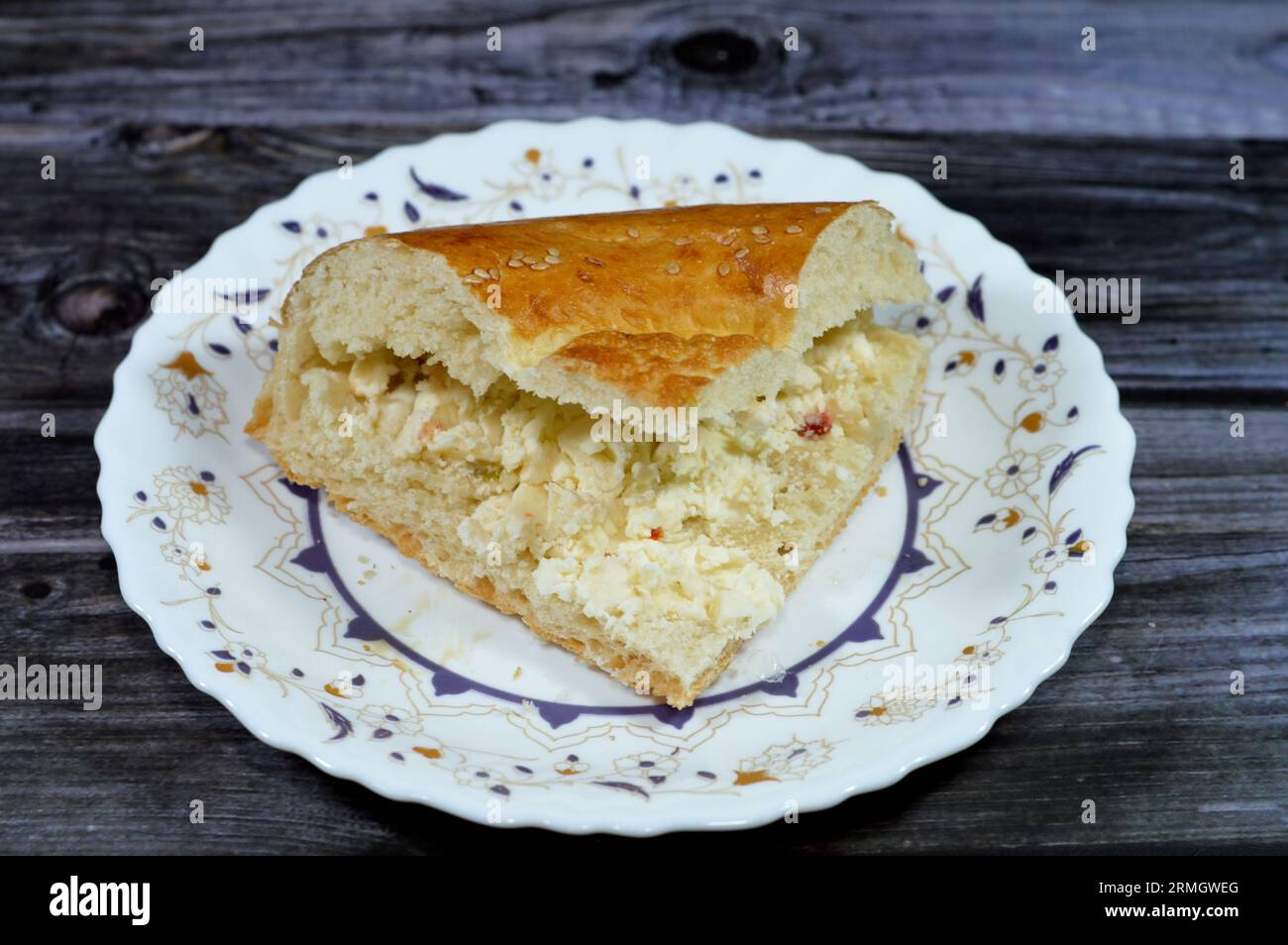 Fromage blanc à l'intérieur d'un morceau d'un pain ouzbek tandyr Nan, un type de pain d'Asie centrale, souvent décoré par estampage de motifs sur la pâte à l'aide d'un b. Banque D'Images