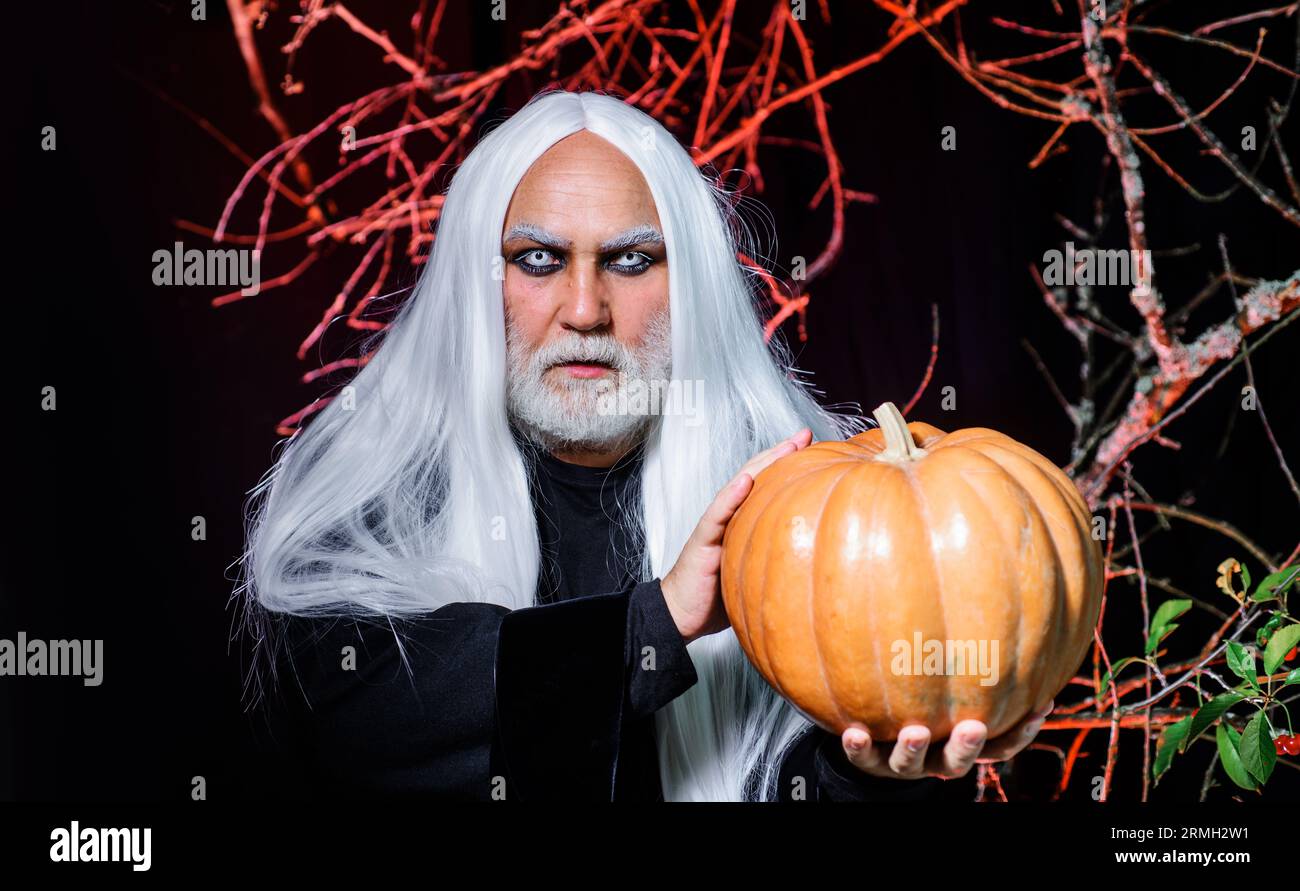 Halloween horreur. Démon mâle avec Jack-o-Lantern. Homme vampire diable avec citrouille Halloween. Sorcier magicien vieil homme avec citrouille sur la nuit d'Halloween Banque D'Images