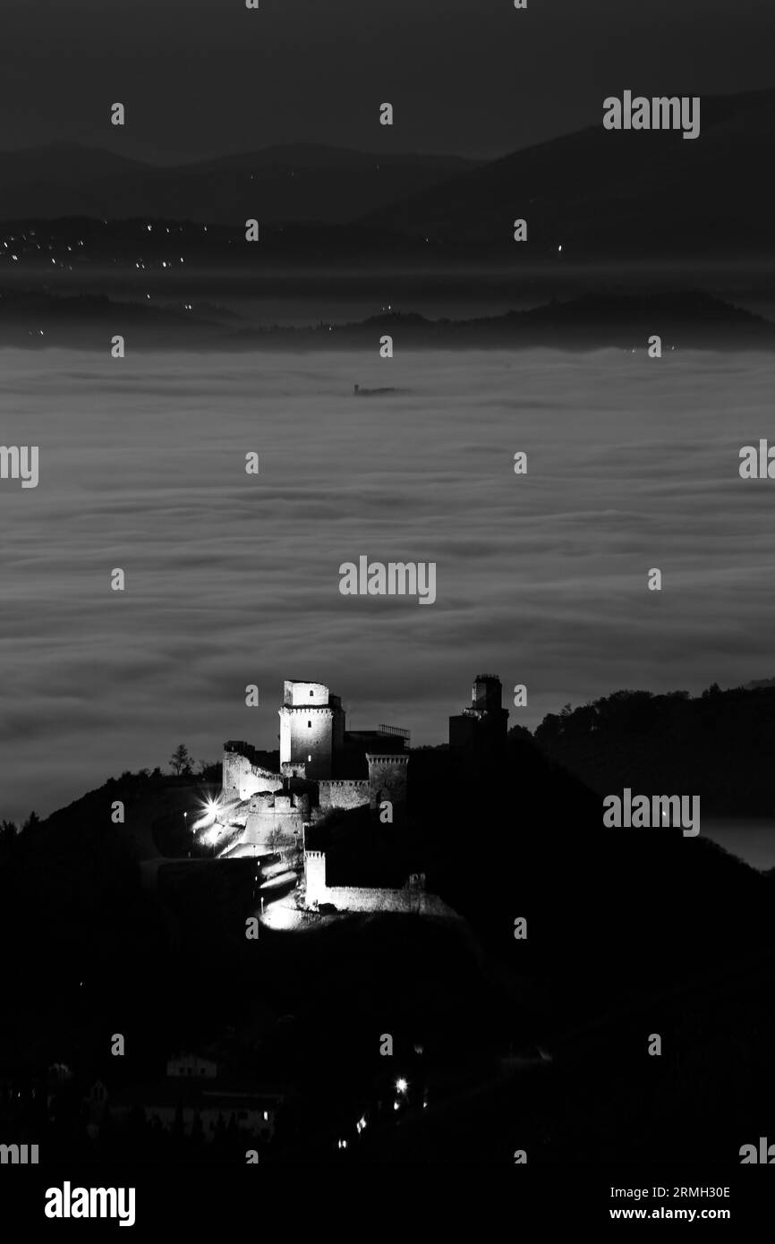 Vue de Rocca Maggiore Assise Ombrie Italie au-dessus d'une mer de brouillard la nuit, pendant Noël 2023 Banque D'Images