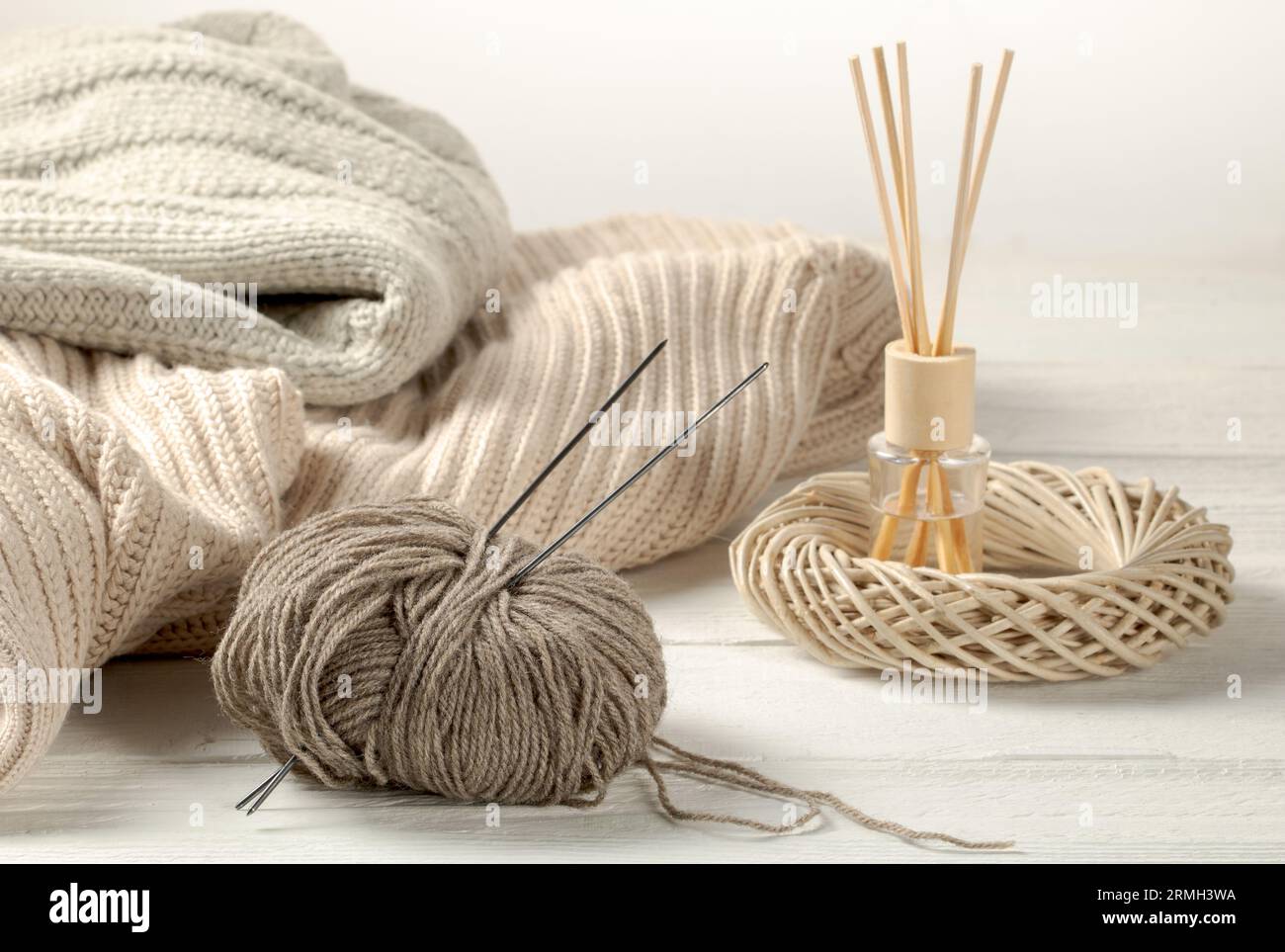 Intérieur confortable de la maison - des choses tricotées et des boules de fils de laine sur une table en bois. Banque D'Images