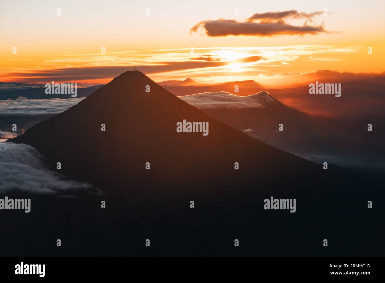 Le soleil se lève derrière le volcan Agua au Guatemala, projetant une silhouette dramatique Banque D'Images