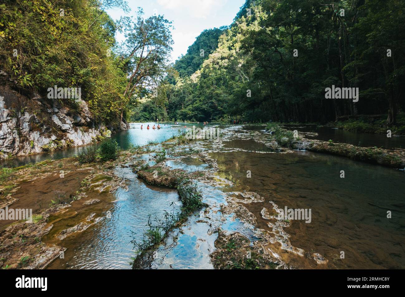 La rivière Cahabón tombe dans des niveaux de piscines sur le monument naturel de Semuc Champey, Guatemala. Les nageurs en tirent le meilleur parti par un après-midi ensoleillé Banque D'Images