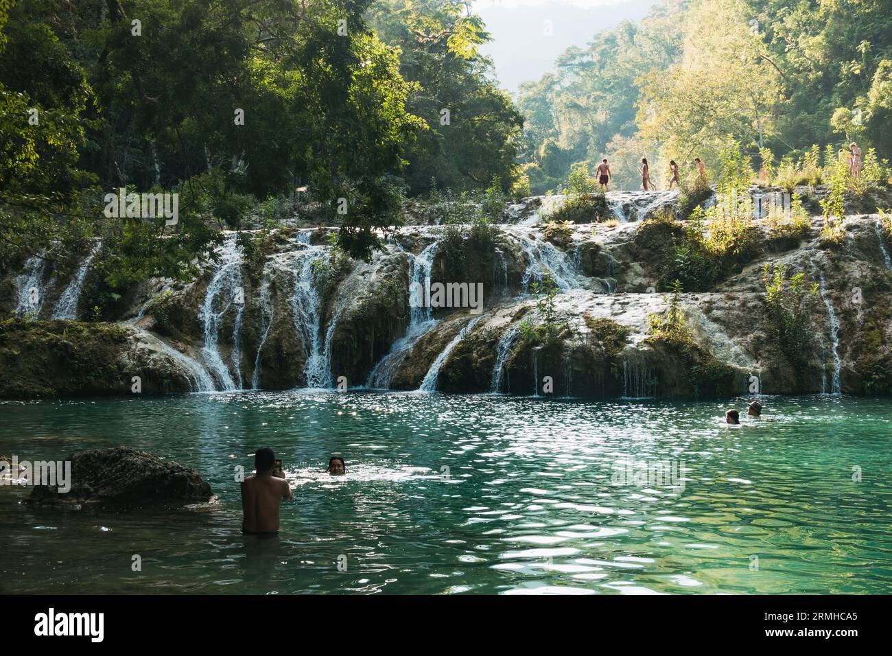 La rivière Cahabón tombe dans des niveaux de piscines sur le monument naturel de Semuc Champey, Guatemala. Les nageurs en tirent le meilleur parti par un après-midi ensoleillé Banque D'Images