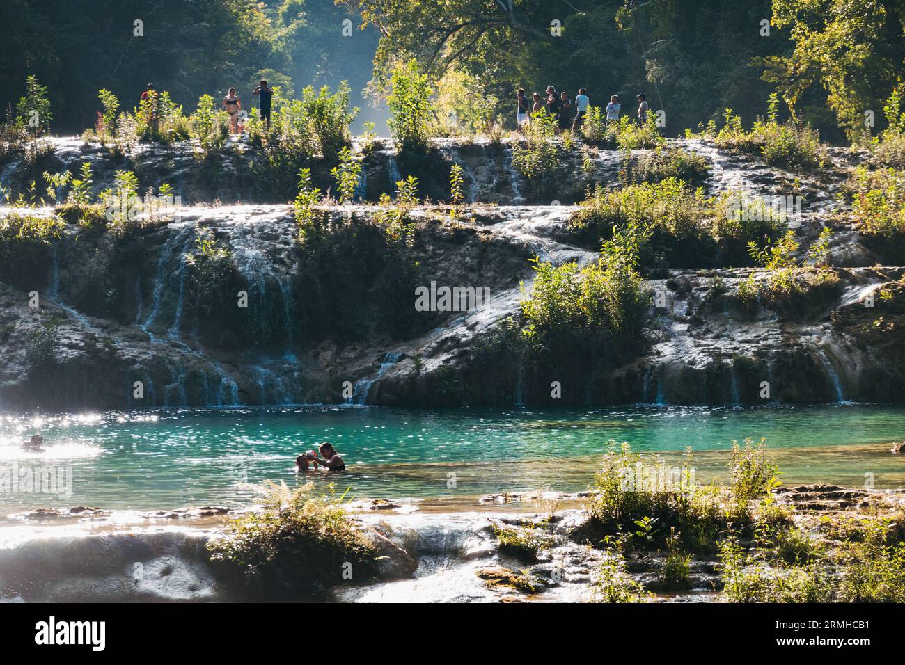 La rivière Cahabón tombe dans des niveaux de piscines sur le monument naturel de Semuc Champey, Guatemala. Les nageurs en tirent le meilleur parti par un après-midi ensoleillé Banque D'Images