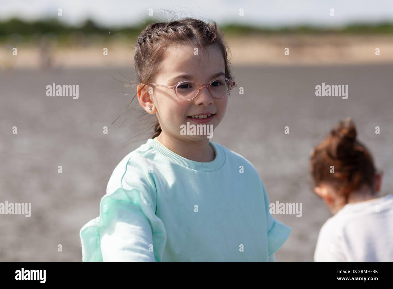 Deux petites filles jouent joyeusement sur le bord de mer à marée basse. Sœurs en vacances sur la côte Banque D'Images