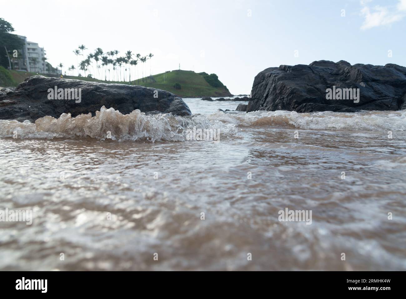 L'eau de plage coule entre les rochers noirs. Sensation de détente. Banque D'Images