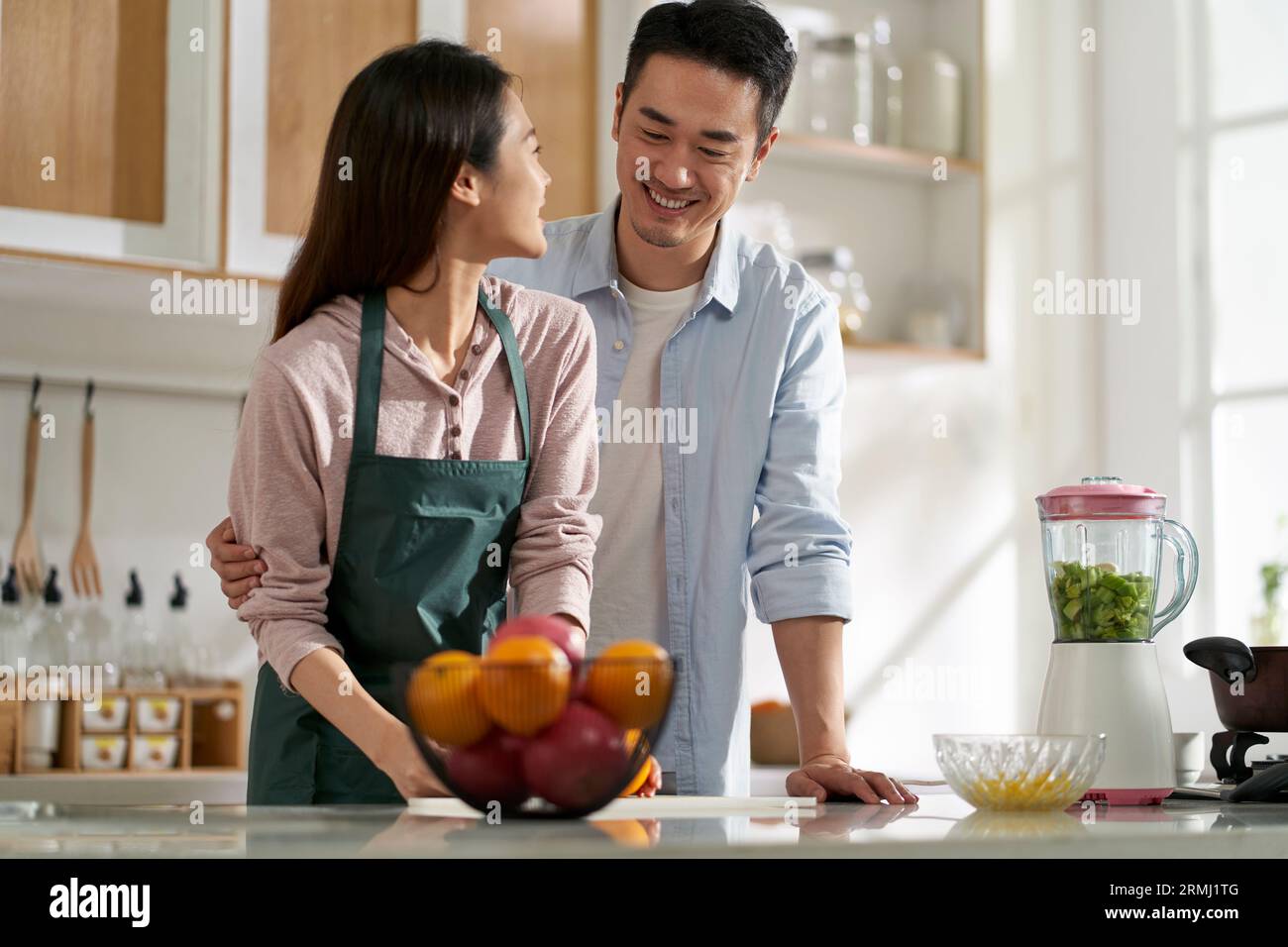 amoureux jeune couple asiatique bavardant en discutant dans la cuisine à la maison tout en préparant la nourriture Banque D'Images