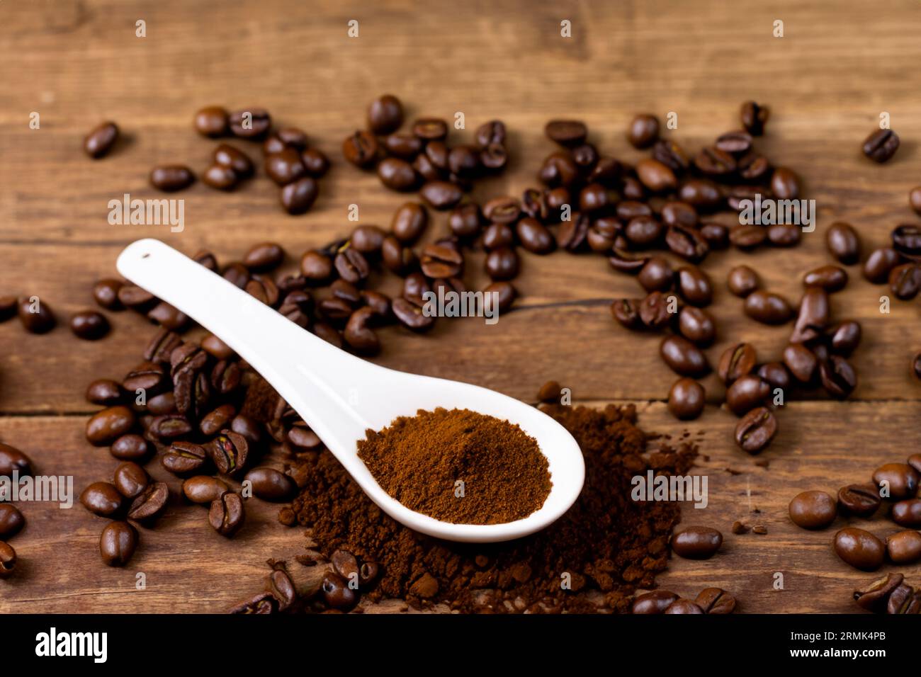 cuillère avec de la poudre et des grains de café sur une vieille cuillère en bois Banque D'Images