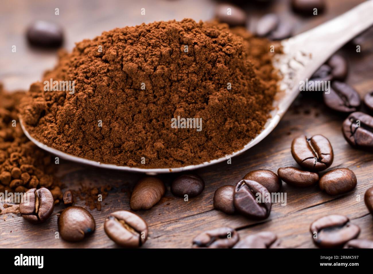 cuillère avec de la poudre et des grains de café sur une vieille cuillère en bois Banque D'Images
