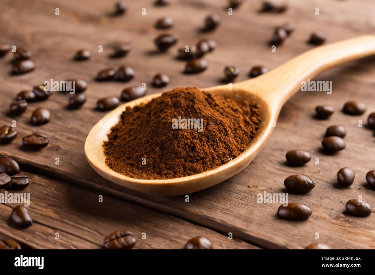 cuillère avec de la poudre et des grains de café sur une vieille cuillère en bois Banque D'Images
