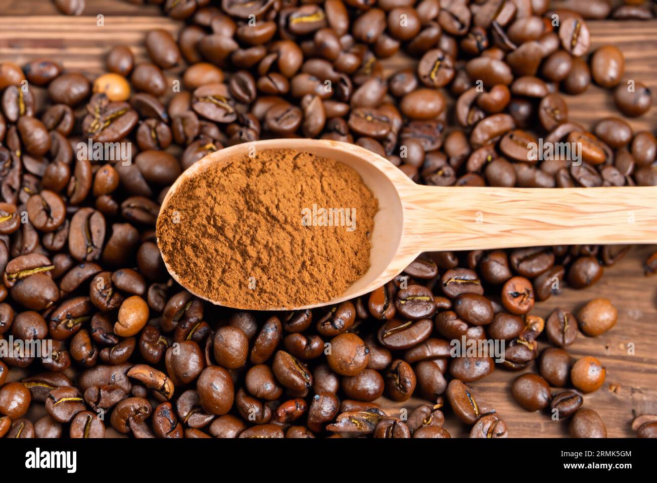 cuillère avec de la poudre et des grains de café sur une vieille cuillère en bois Banque D'Images