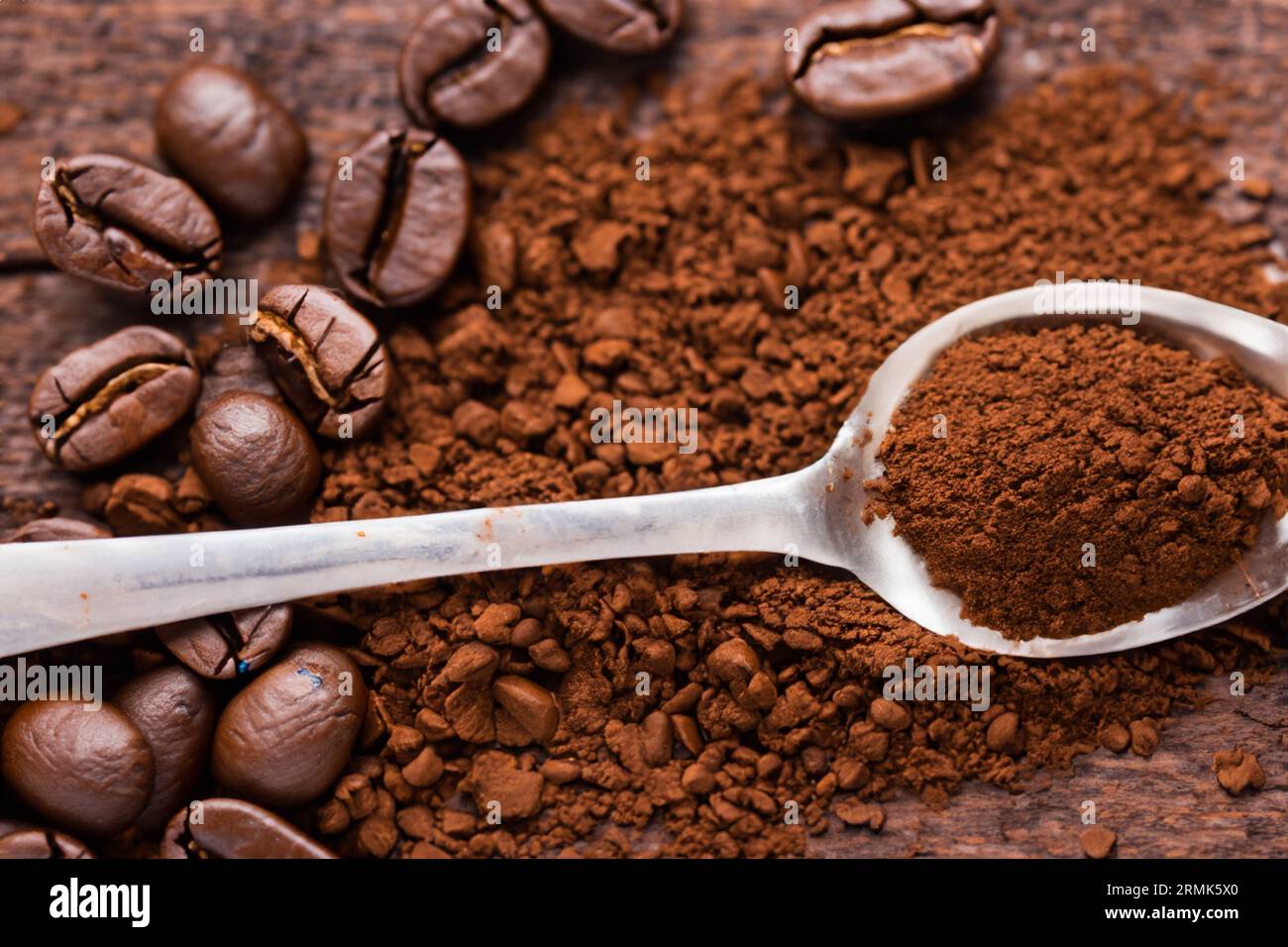 cuillère avec de la poudre et des grains de café sur une vieille cuillère en bois Banque D'Images