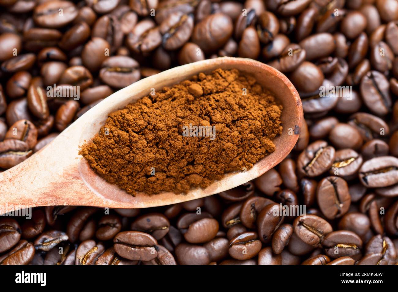 cuillère avec de la poudre et des grains de café sur une vieille cuillère en bois Banque D'Images