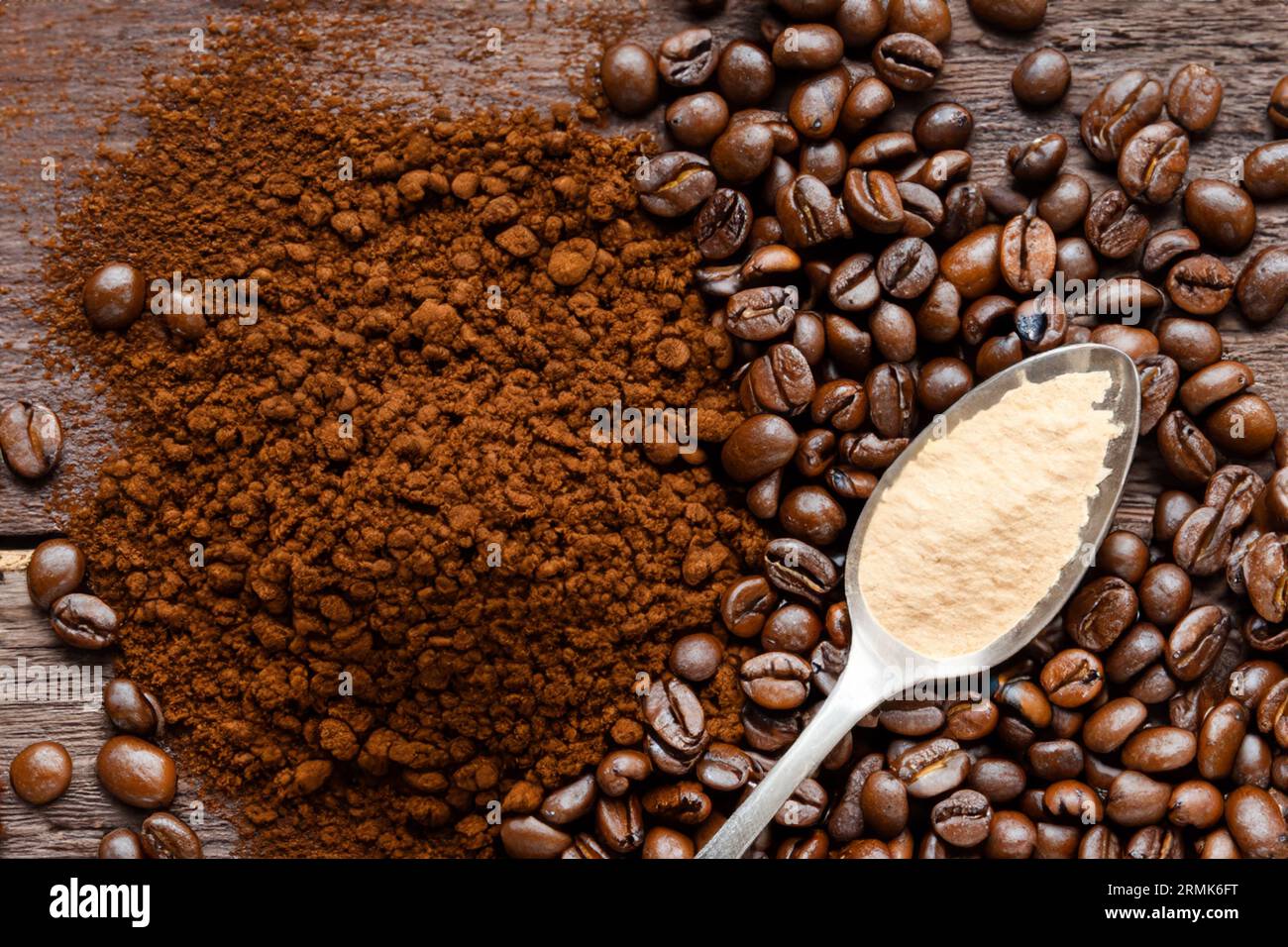 cuillère avec de la poudre et des grains de café sur une vieille cuillère en bois Banque D'Images