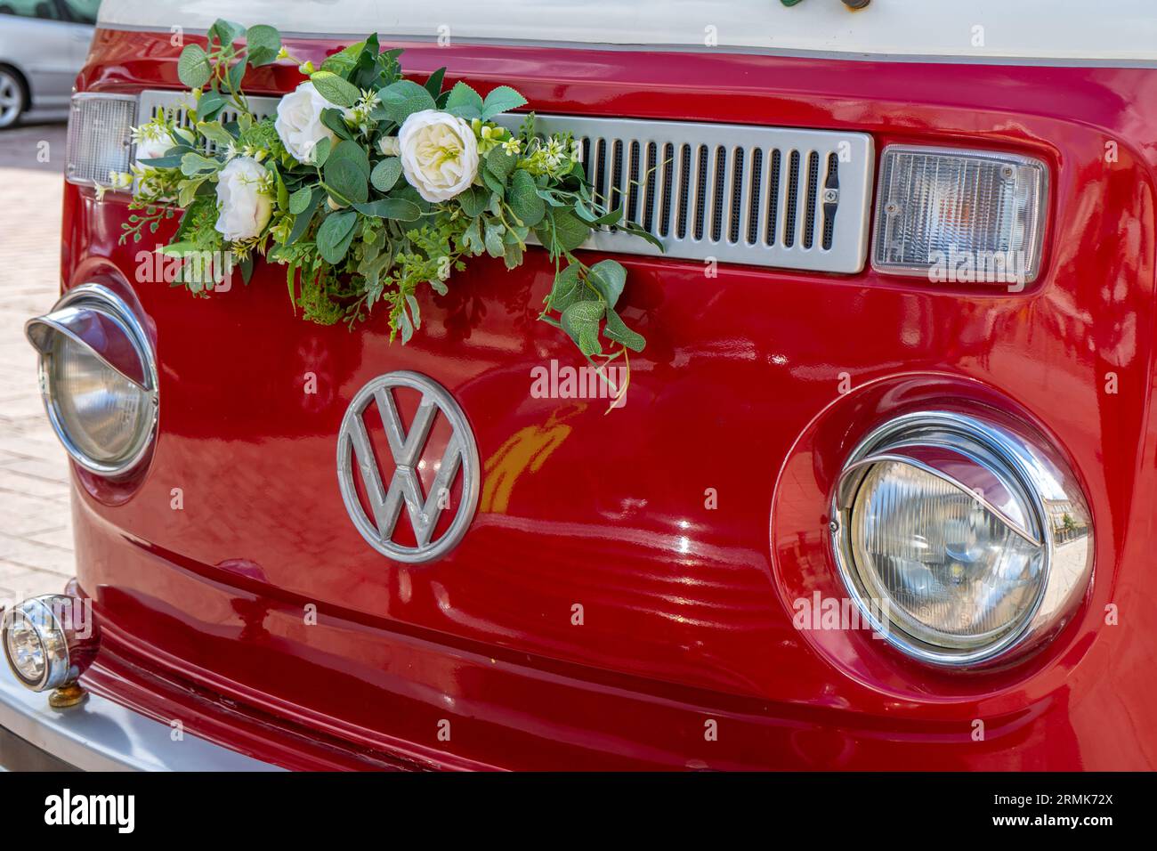 Voiture des jeunes mariés. Minibus rouge volkswagen. Voiture de bus rétro. Décoré de bouquets de fleurs. Décor festif, bouquet de mariée. Juste marié. Pologne, Varsovie - 30 juillet 2023. Banque D'Images