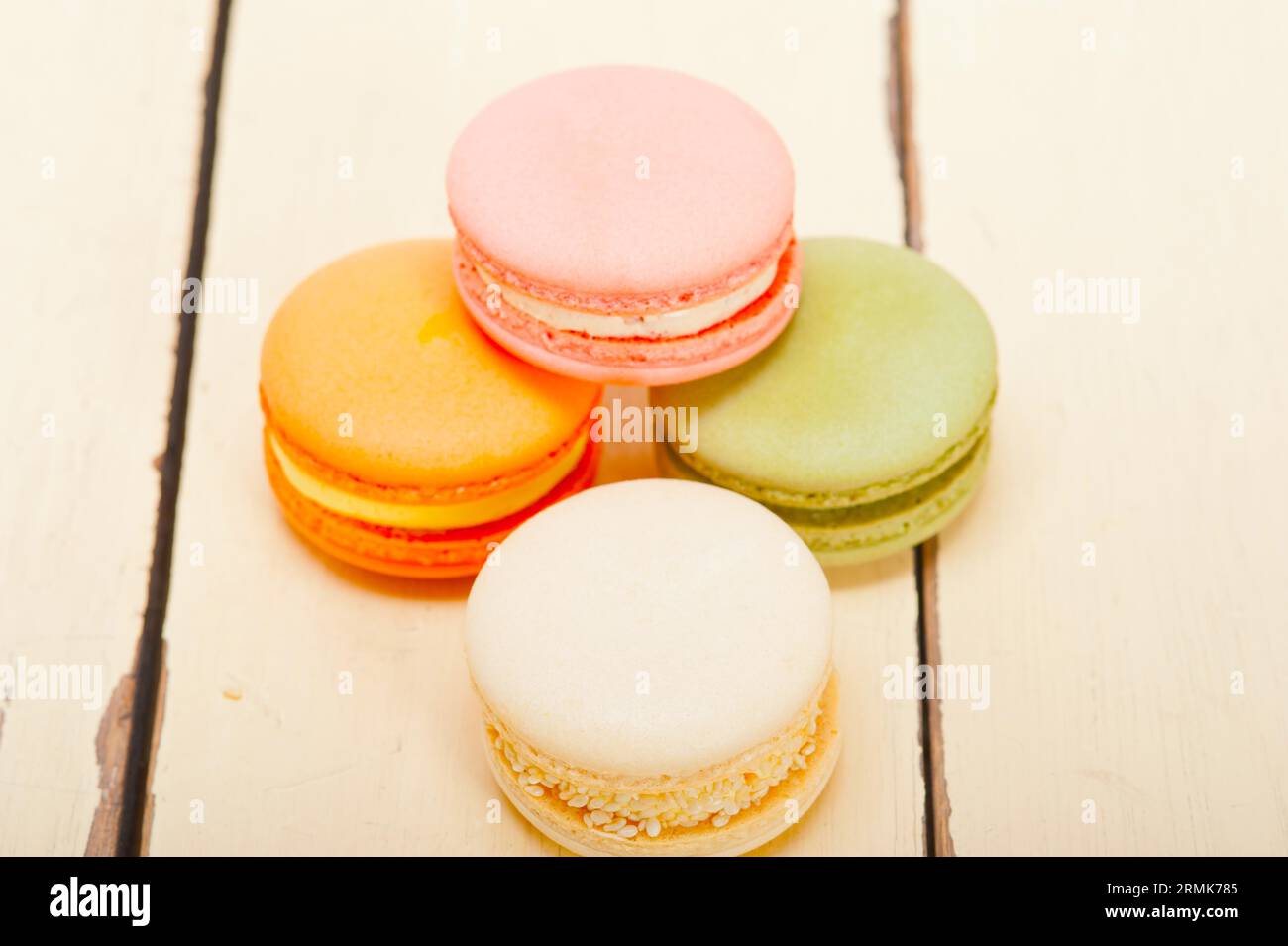 Macarons français colorés sur une table en bois rustique blanc Banque D'Images