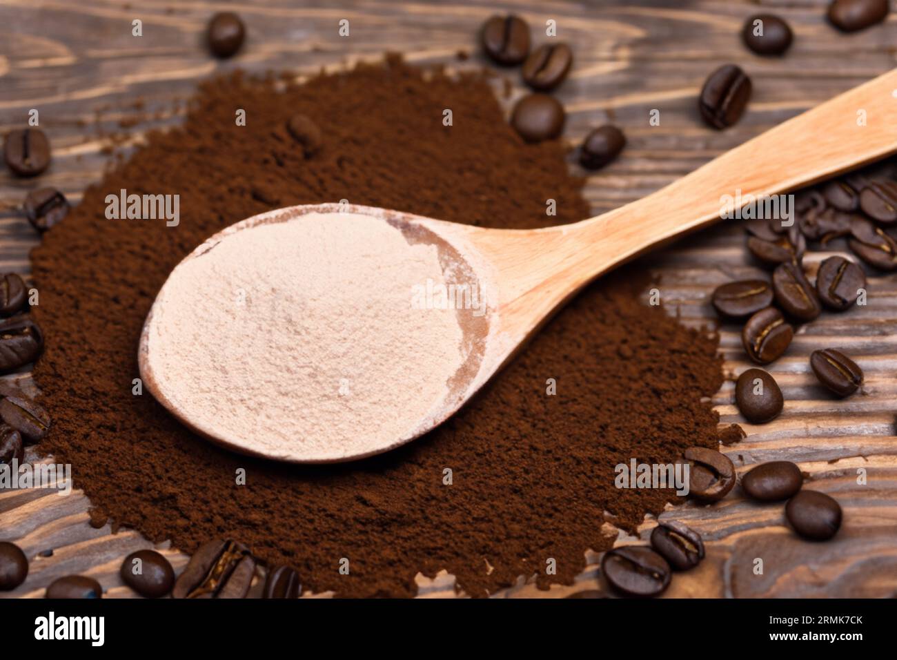 cuillère avec de la poudre et des grains de café sur une vieille cuillère en bois Banque D'Images