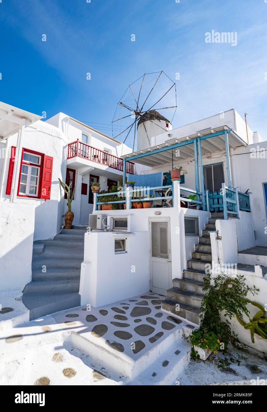 Maisons blanches cycladiques aux volets colorés, moulin à vent Bonis à l'arrière, ruelles de la vieille ville de Chora, Mykonos Town, Mykonos, Cyclades, Grèce Banque D'Images