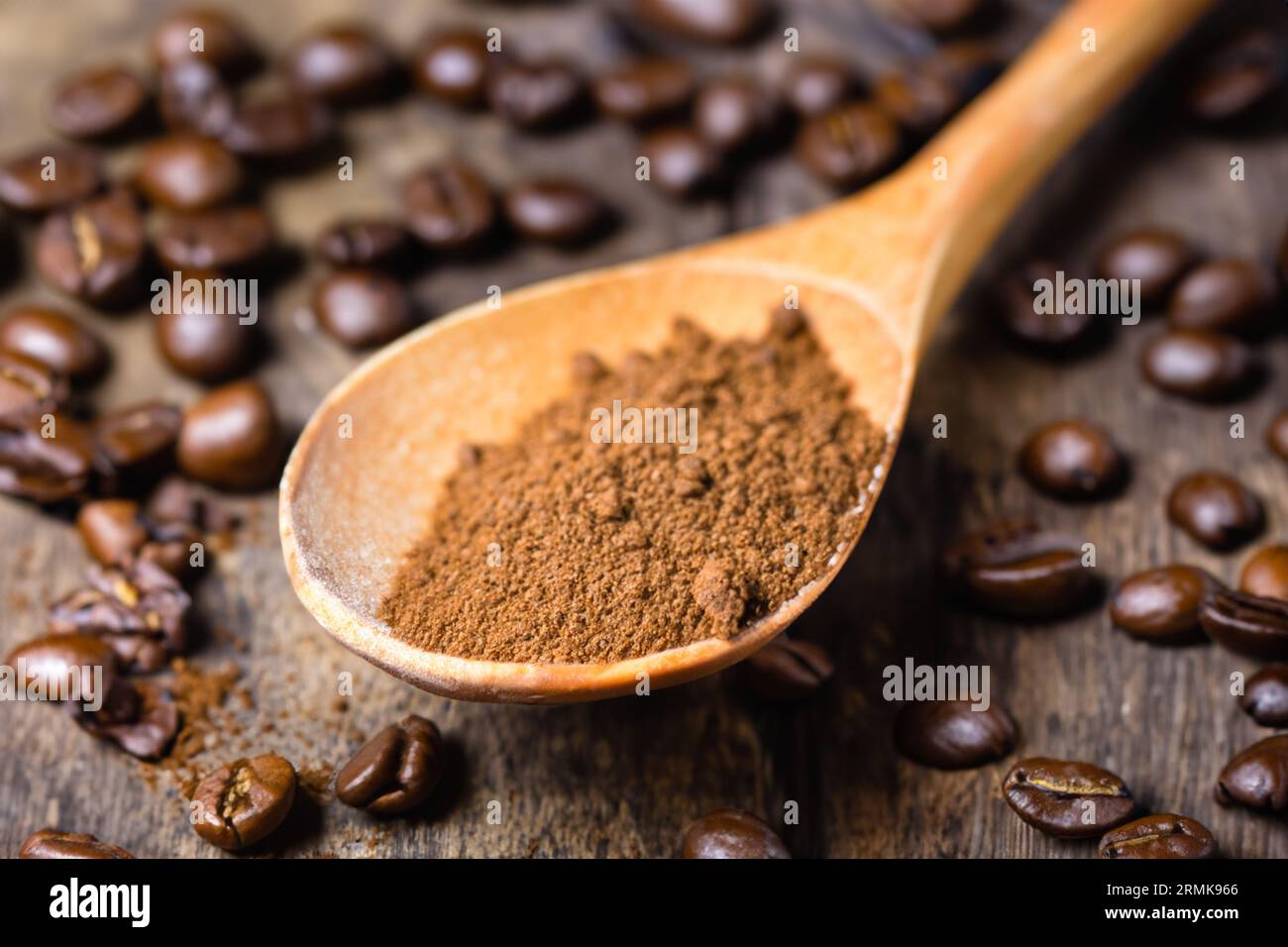 cuillère avec de la poudre et des grains de café sur une vieille cuillère en bois Banque D'Images