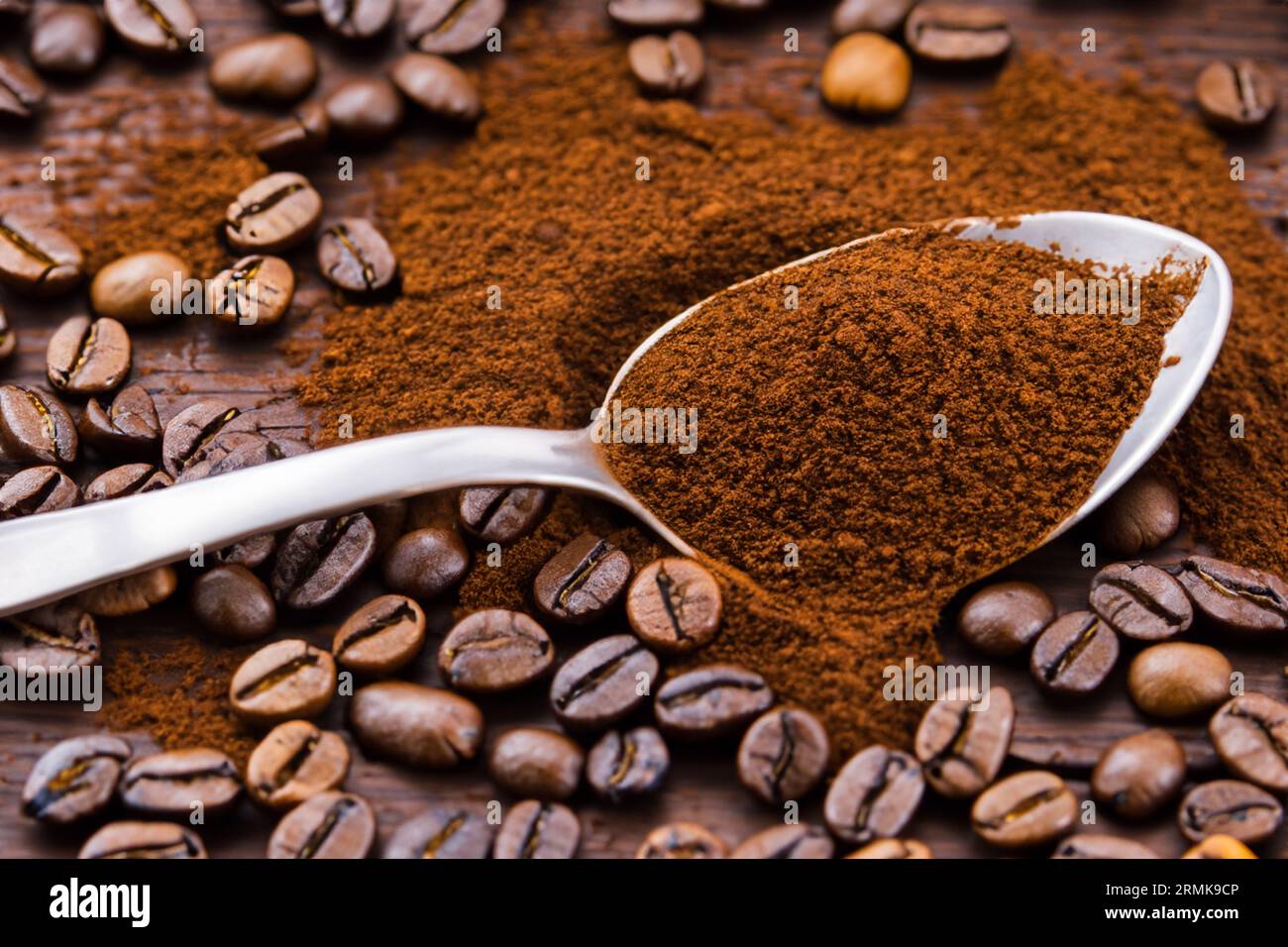 cuillère avec de la poudre et des grains de café sur une vieille cuillère en bois Banque D'Images