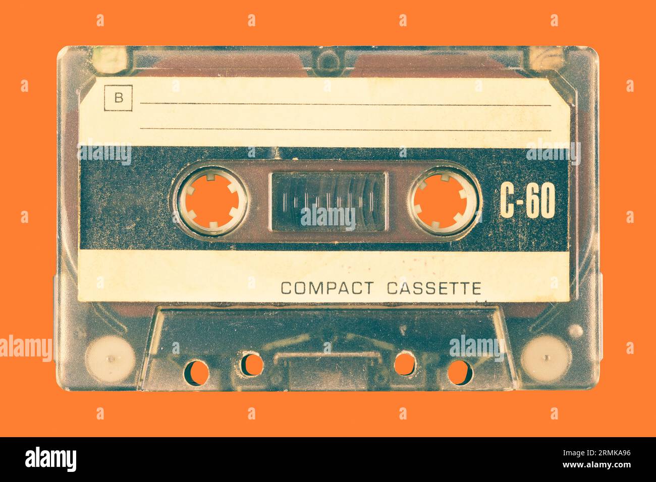 Ancienne cassette compacte audio vintage devant un fond orange Banque D'Images