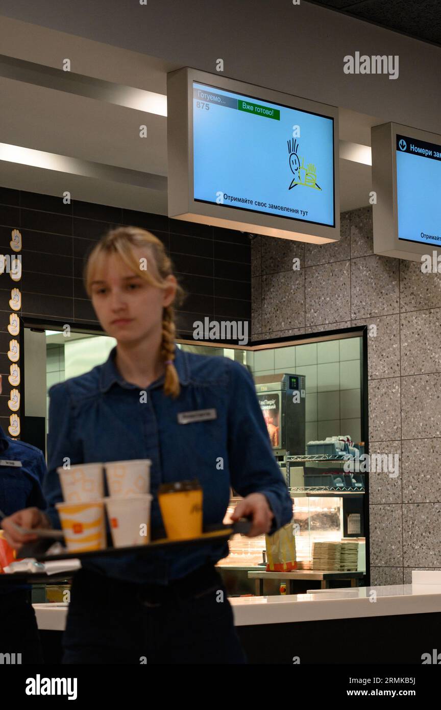 Ivano-Frankivsk, Ukraine, 7 juin 2023 : un serveur de McDonald's porte une commande prête à l'emploi sur un plateau, un restaurant de restauration rapide. Banque D'Images