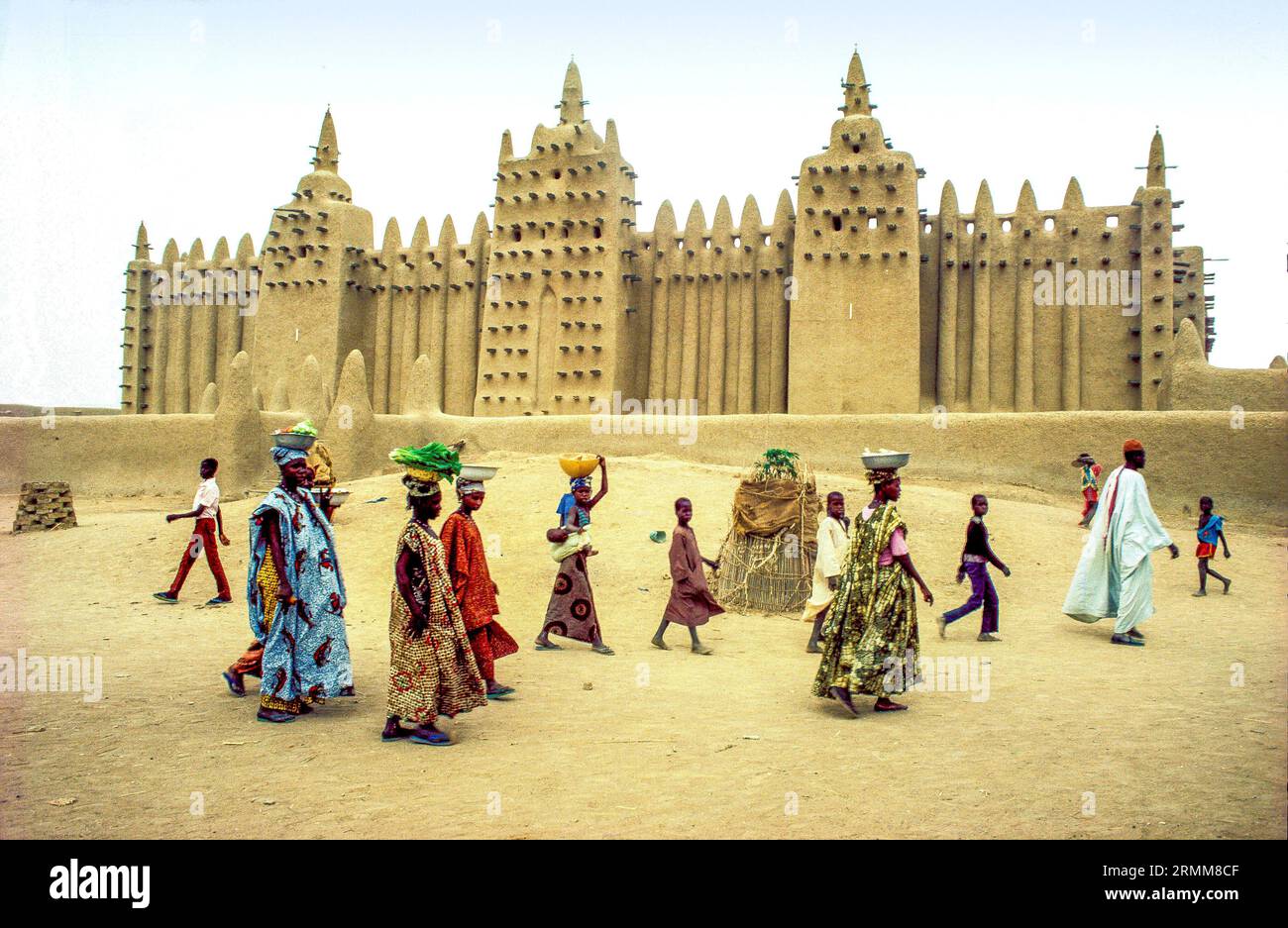 Mali, Djenne. Personnes passant la mosquée adobe du patrimoine de l'UNESCO. Banque D'Images