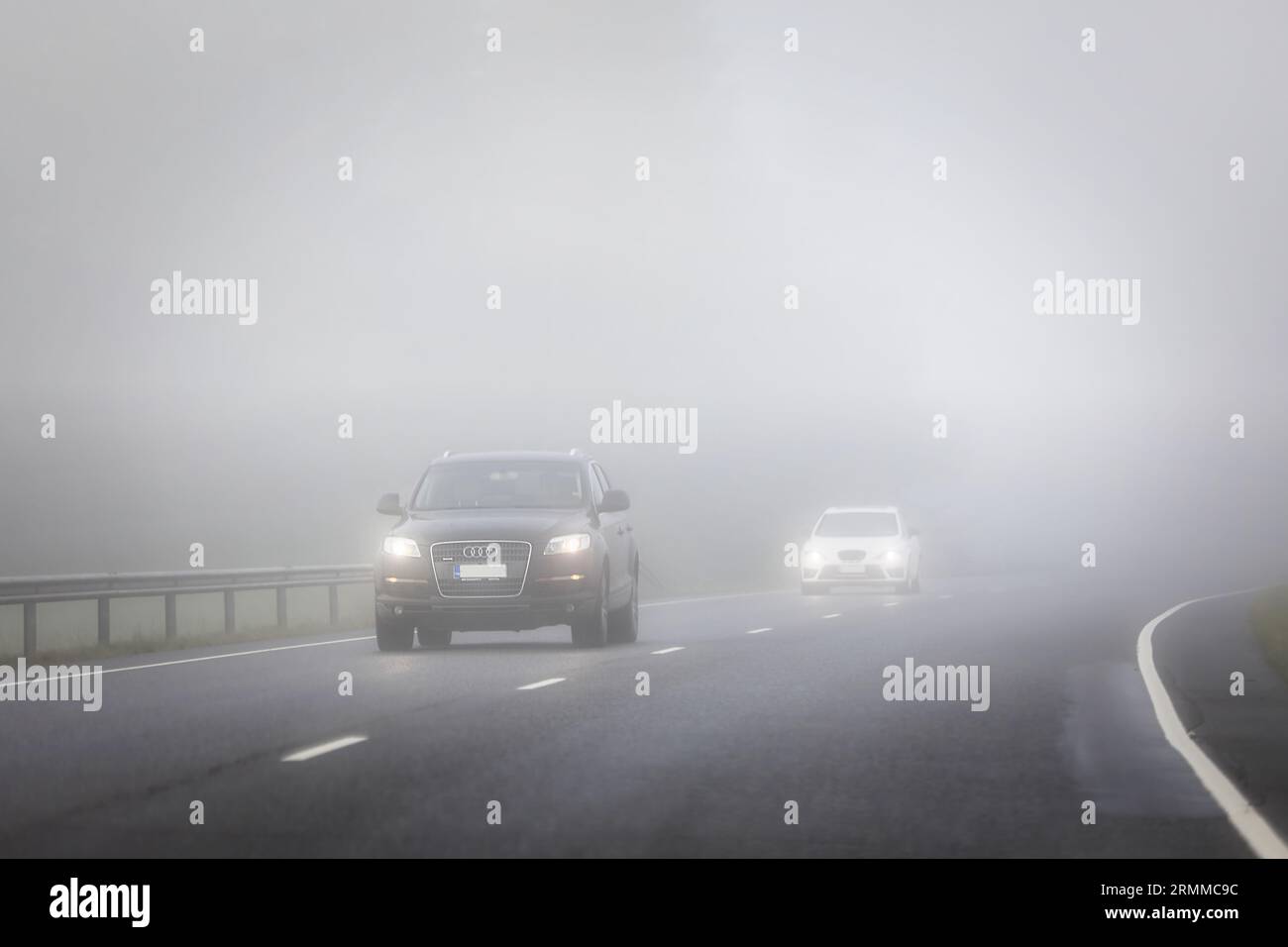 Voitures roulant sur l'autoroute, apparaissant à travers le brouillard dense. Salo, Finlande. 25 août 2023. Banque D'Images