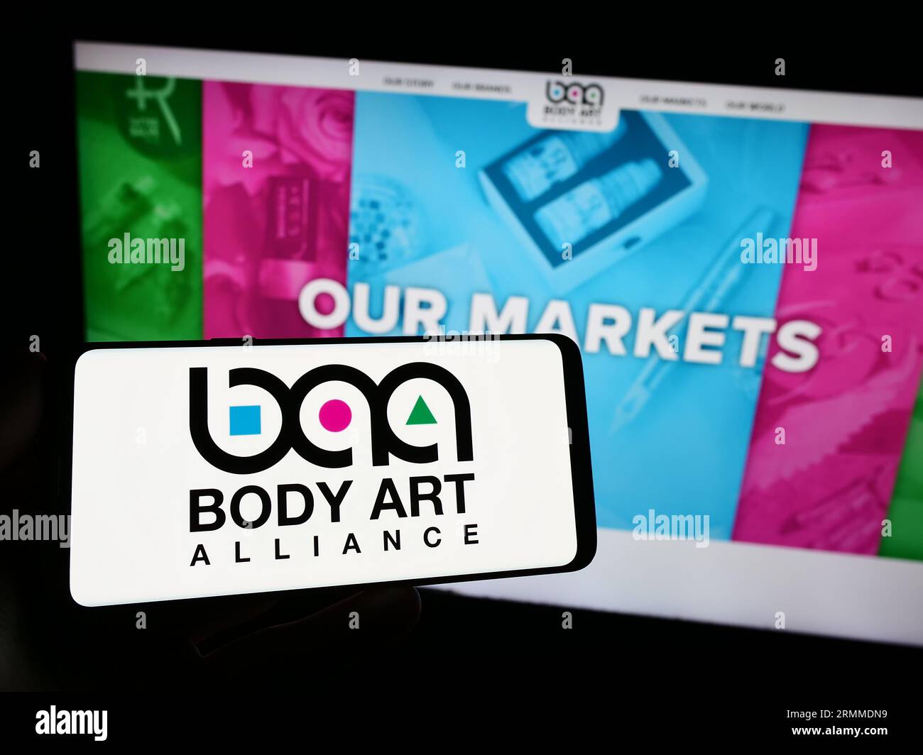 Personne tenant un smartphone avec le logo de la société américaine de cosmétiques Body Art Alliance sur l'écran devant le site Web. Concentrez-vous sur l'affichage du téléphone. Banque D'Images