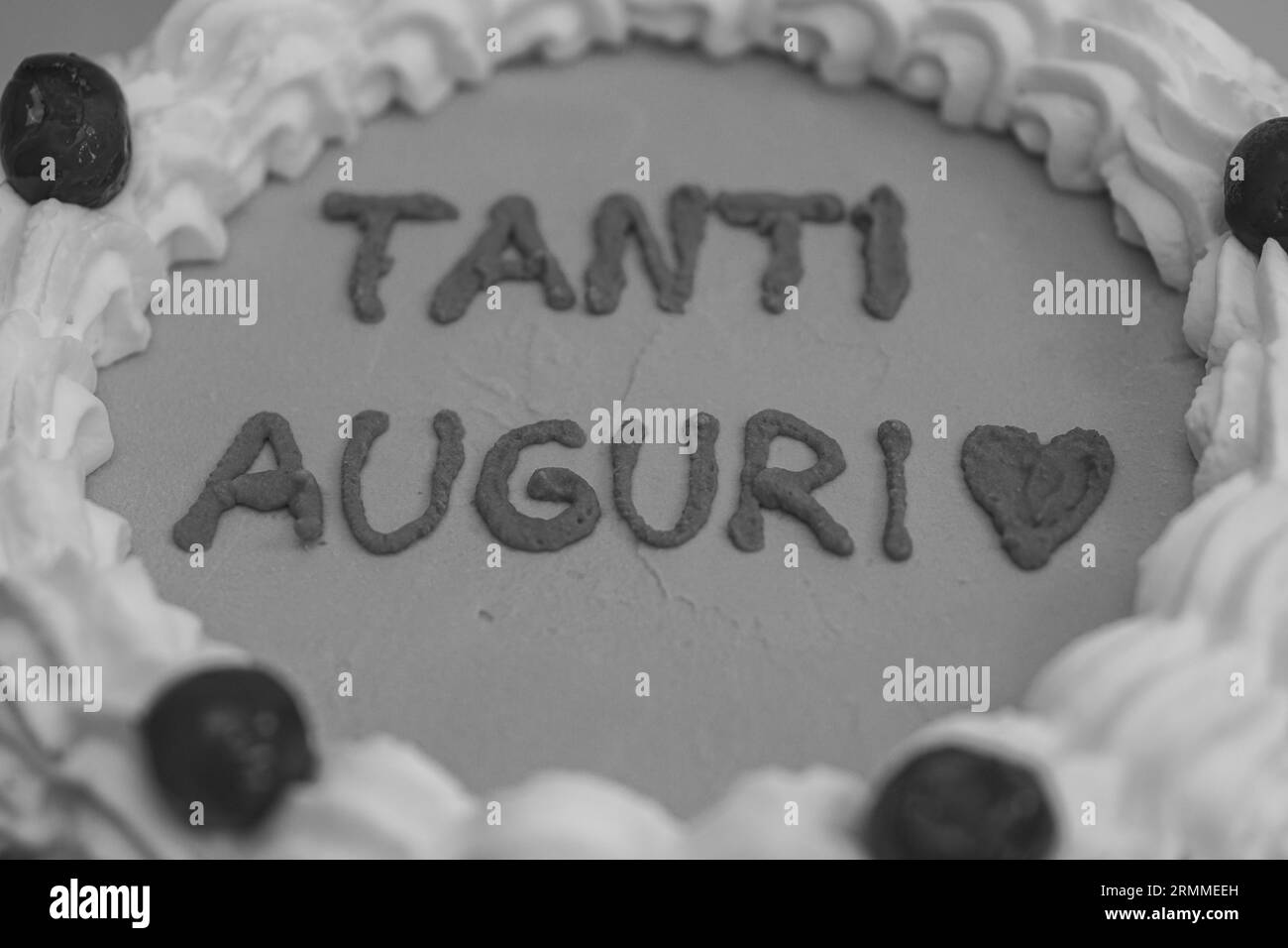 Cupcake rouge rose pour la célébration d'anniversaire isolé sur blanc, lissant topper avec spatule, portant des gants dans la cuisine professionnelle Banque D'Images