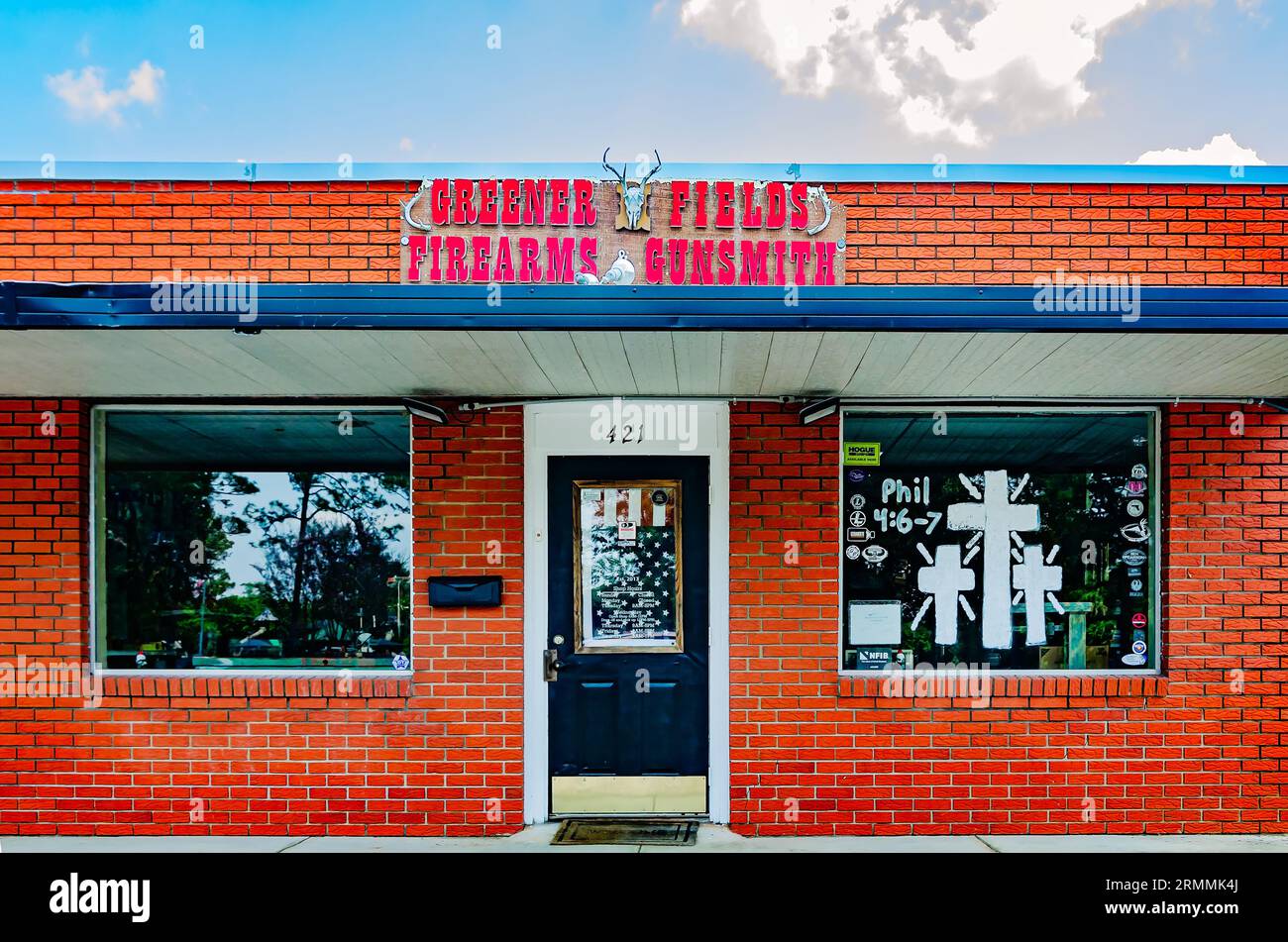 Greener Fields Firearms & Gunsmith présente des versets de la Bible sur la fenêtre et un drapeau américain sur la porte, le 19 août 2023, à Foley, Alabama. Banque D'Images