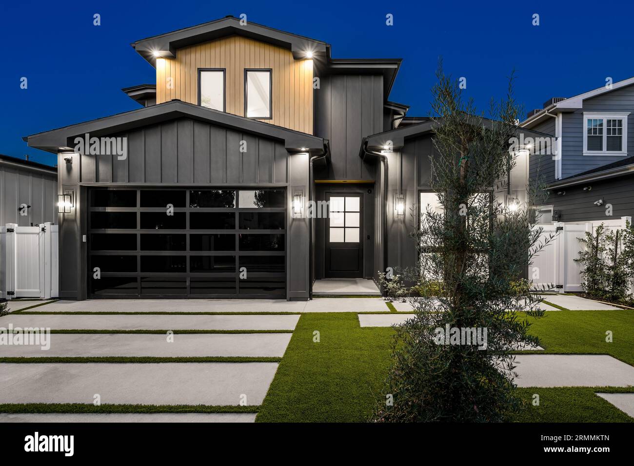 Une grande maison de deux étages avec une clôture de piquet blanche entourant la propriété Banque D'Images