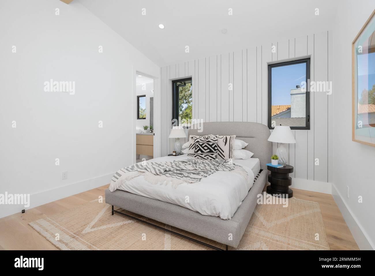 L'intérieur de la chambre principale moderne présente un papier peint contemporain, ainsi qu'un nouveau ventilateur de plafond pour une circulation d'air accrue Banque D'Images