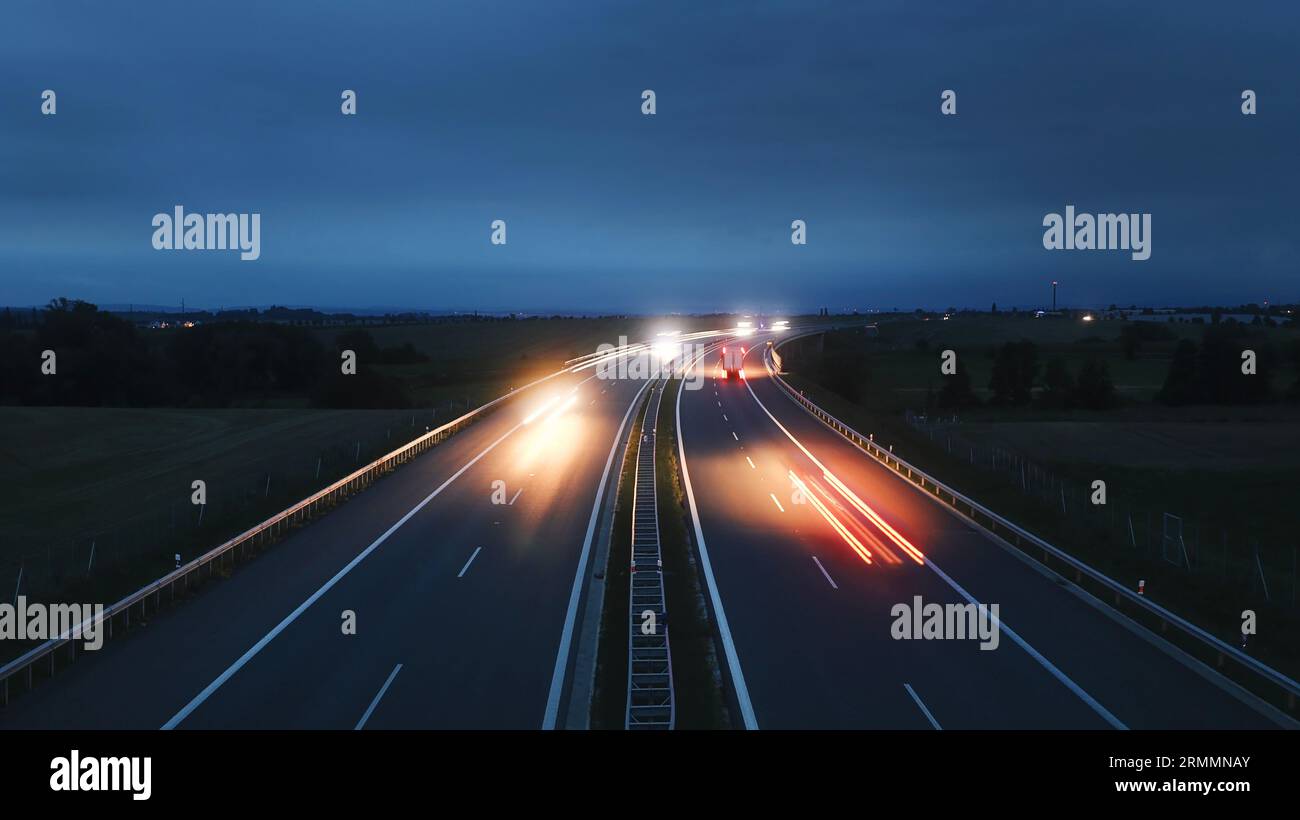Autoroute à voies multiples dans la campagne au crépuscule. Thèmes transport en voiture, direction et connexion. Banque D'Images