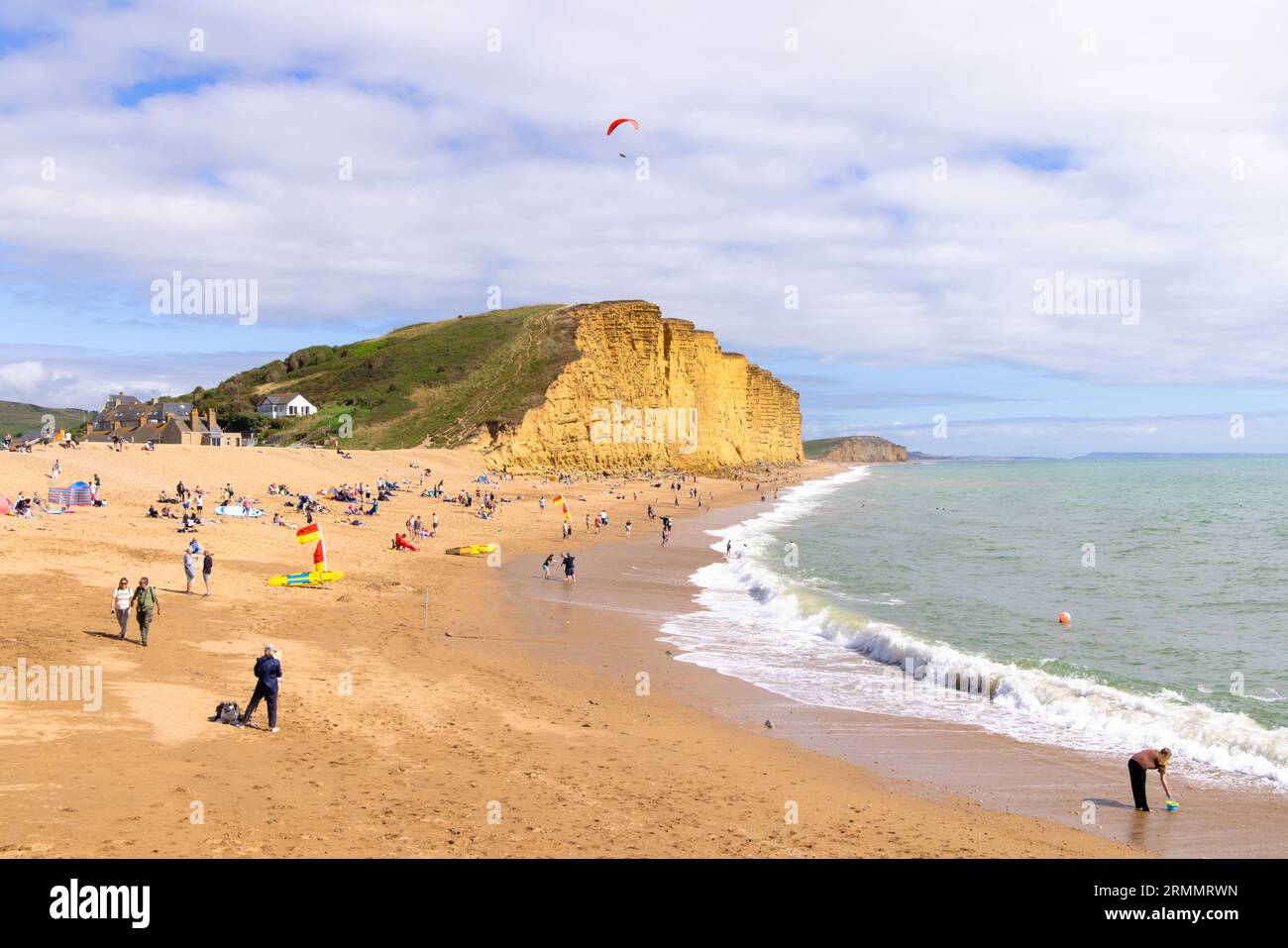 Un parapente parapente sur la plage, West Bay Dorset, plage et falaises, et les gens sur la plage en été ; West Bay, Dorset UK plage. Banque D'Images