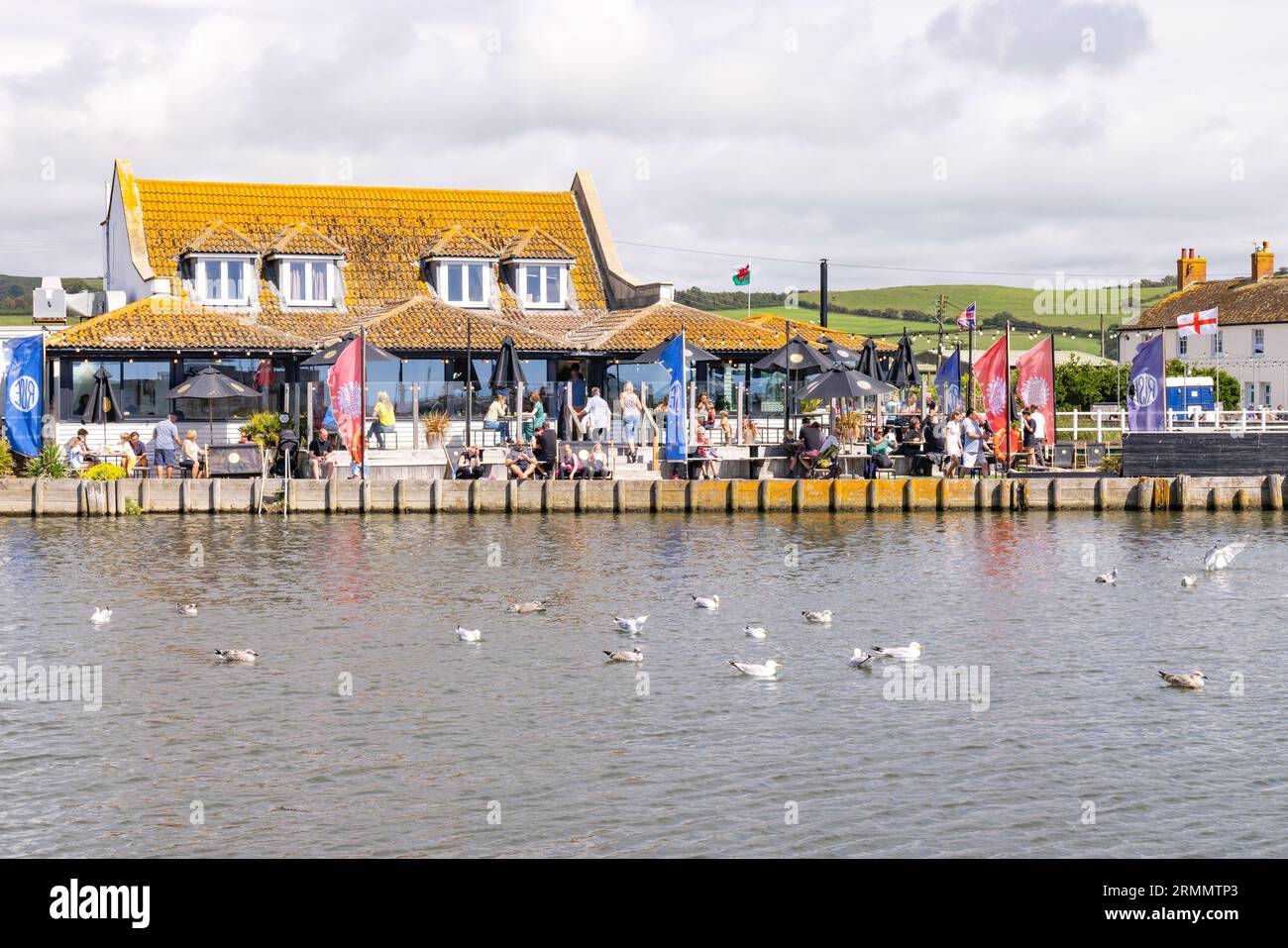 Restaurant UK ; l'extérieur du restaurant Rise, sur la rivière Brit, West Bay, sous le soleil d'été ; West Bay, Bridport, Dorset Royaume-Uni Banque D'Images