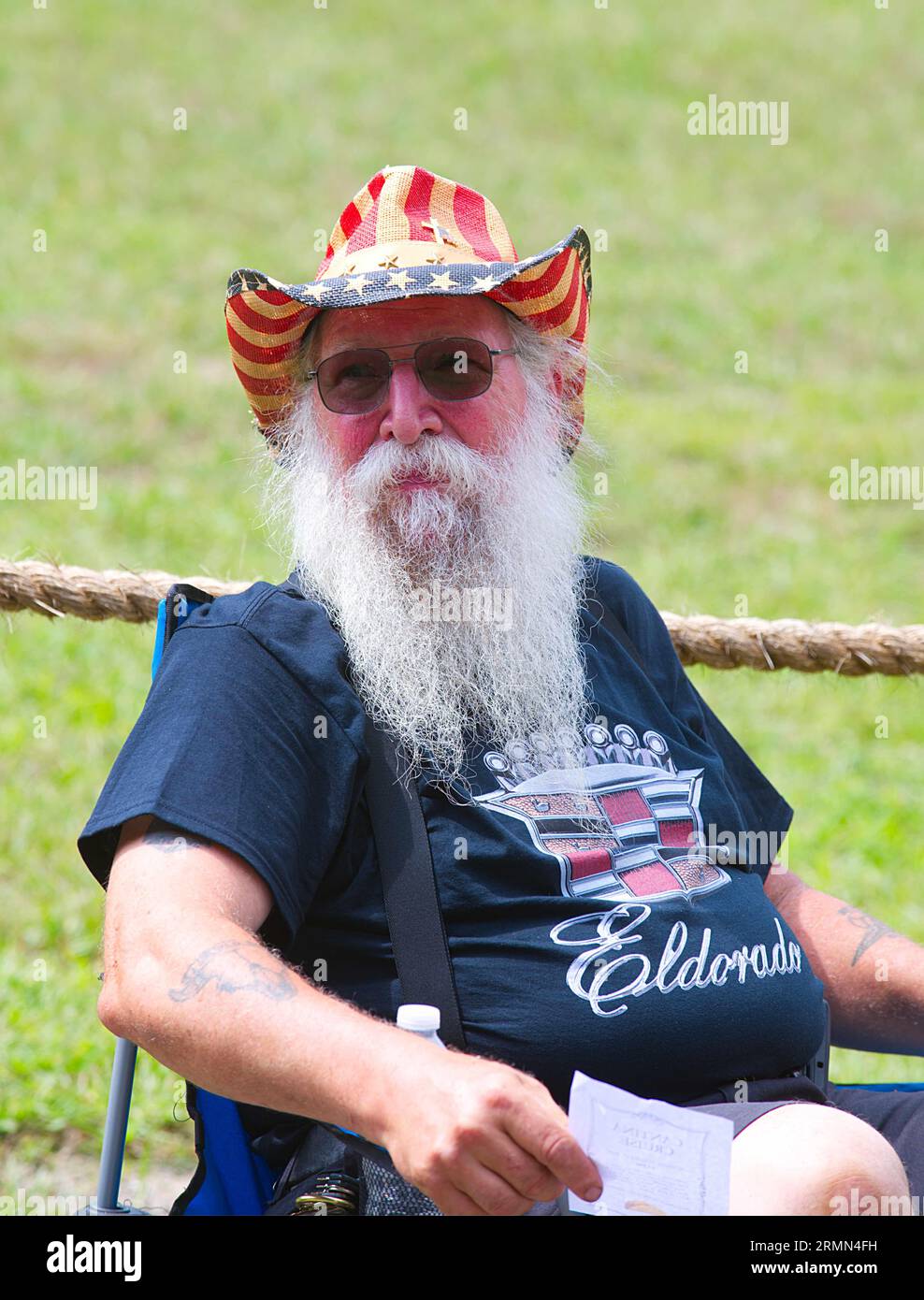 Dennis Festival Days. Un homme barbu est assis à côté de sa voiture après le défilé de l'automobile antique. Banque D'Images