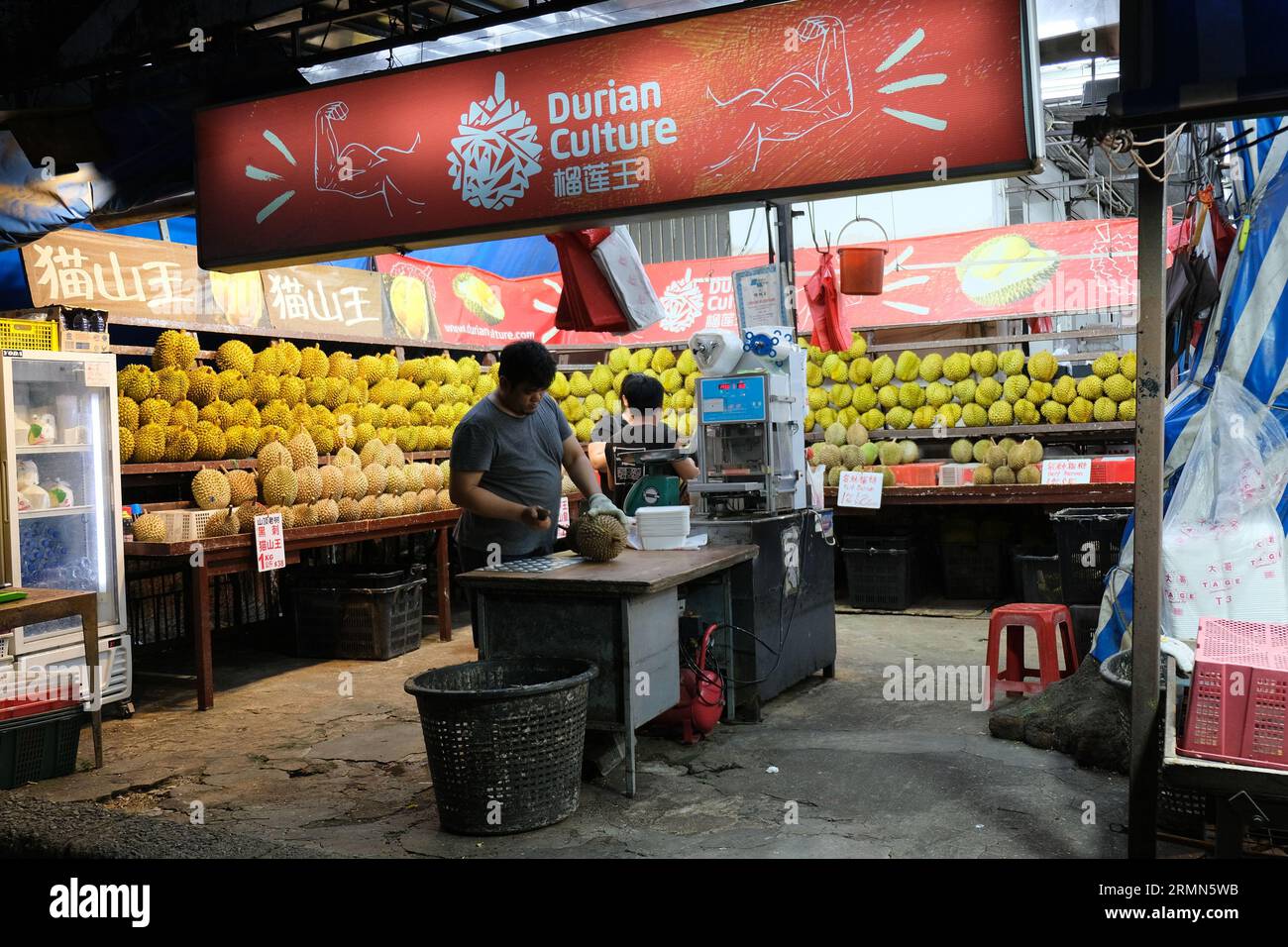 Un vendeur de durian hache les fruits tropicaux piquants dans un étal du district de Geylang à Singapour. 24/09/2022 Banque D'Images