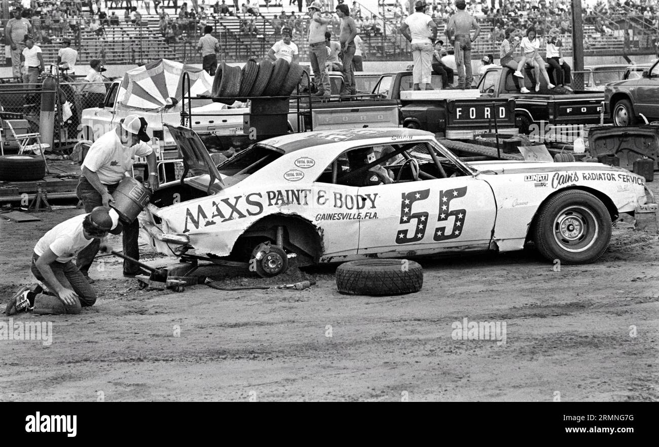 Les équipages amateurs de course de stock-car travaillent sur leurs voitures lors d'un arrêt au stand au Volusia Speedway à Barberville, en Floride, lors d'une course en 1984. Banque D'Images