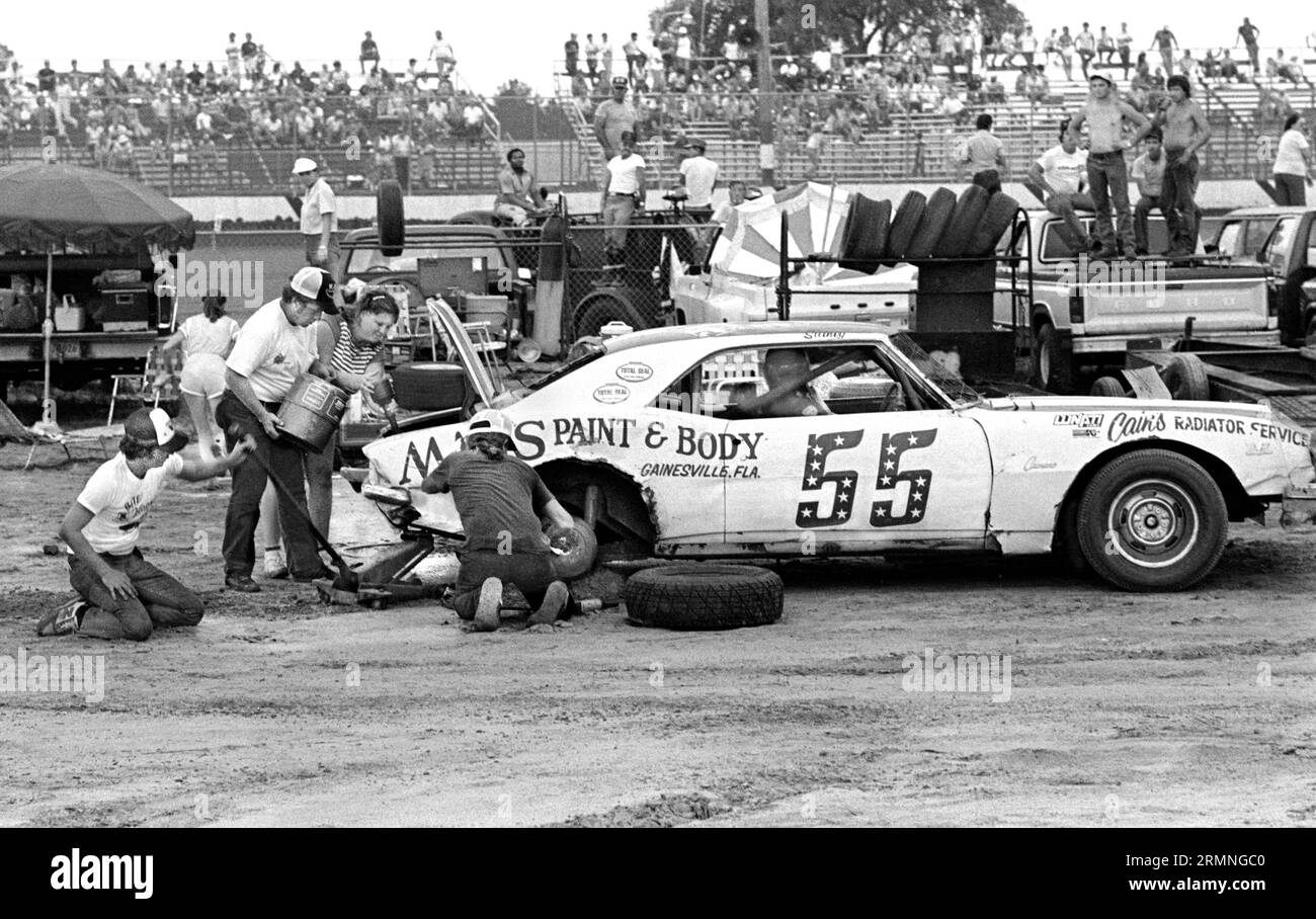 Les équipages amateurs de course de stock-car travaillent sur leurs voitures lors d'un arrêt au stand au Volusia Speedway à Barberville, en Floride, lors d'une course en 1984. Banque D'Images