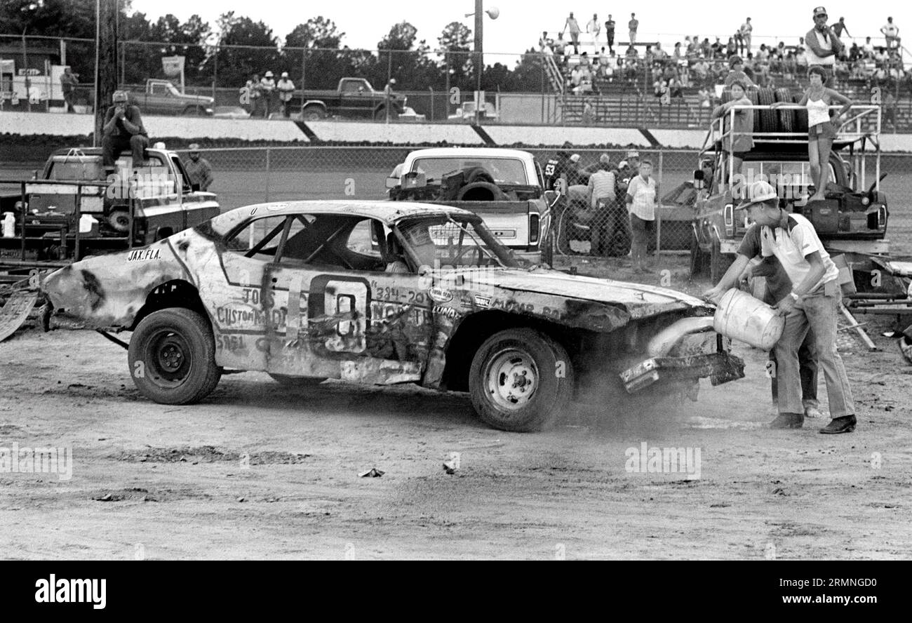 Les équipages amateurs de course de stock-car travaillent sur leurs voitures lors d'un arrêt au stand au Volusia Speedway à Barberville, en Floride, lors d'une course en 1984. Banque D'Images