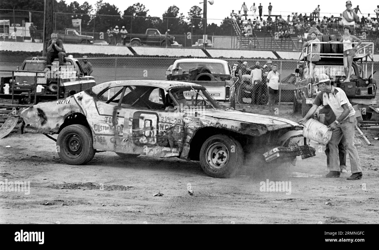 Les équipages amateurs de course de stock-car travaillent sur leurs voitures lors d'un arrêt au stand au Volusia Speedway à Barberville, en Floride, lors d'une course en 1984. Banque D'Images