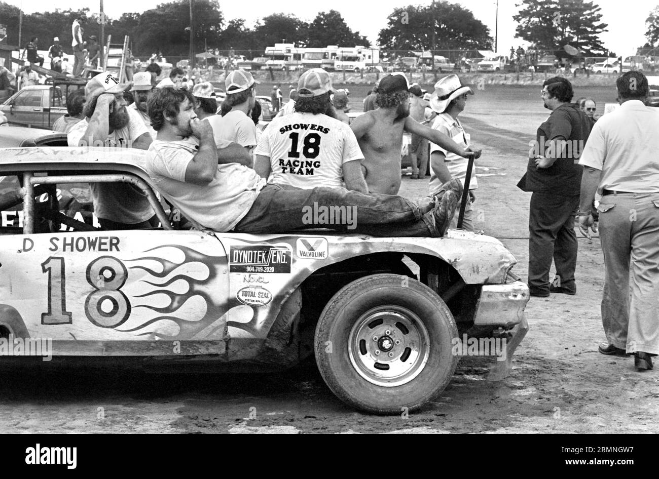 Les membres de l'équipage de course de stock-car amateurs du week-end se détendent avant le départ d'une course de 1984 au Volusia Speedway à Barberville, Floride. Banque D'Images Les membres de l'équipage de course de stock-car amateurs du week-end se détendent avant le départ d'une course de 1984 au Volusia Speedway à Barberville, Floride. Banque D'Images