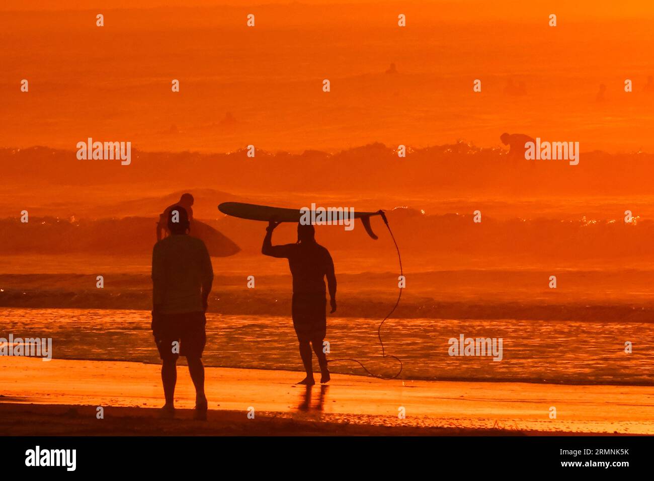 Île de Palms, États-Unis. 29 août 2023. Les surfeurs silhouettés par le lever du soleil vérifient les conditions de vagues causées par le passage de l'ouragan Franklin avant de partir dans l'eau, le 29 août 2023 à Isle of Palms, Caroline du Sud. L’ouragan Franklin, une tempête monstre de catégorie 4, se dirige vers les Bermudes tandis que l’ouragan Idalia devrait passer au-dessus de ses têtes jeudi. Crédit : Richard Ellis/Richard Ellis/Alamy Live News Banque D'Images