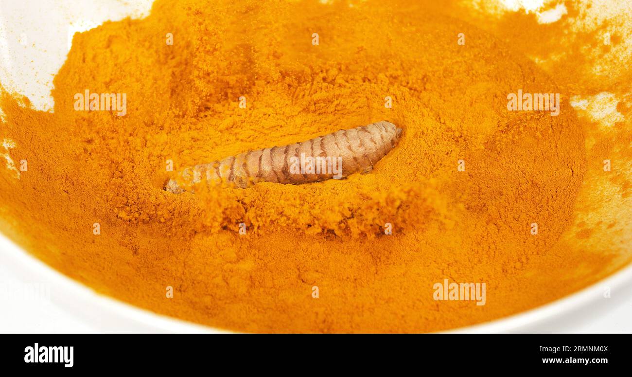 Curcuma, curcuma longa, racine tombant sur poudre de curcuma, épices indiennes Banque D'Images