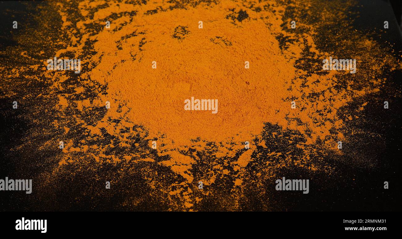 Curcuma, curcuma longa, poudre tombant sur fond noir, épices indiennes Banque D'Images