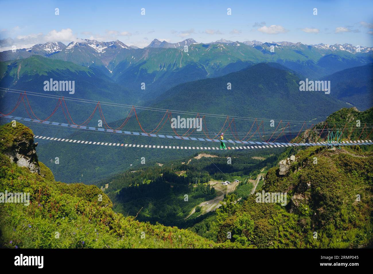 Femme courrant marchant sur le pont suspendu de corde dans les montagnes du caucase, Russie. Photo de haute qualité Banque D'Images
