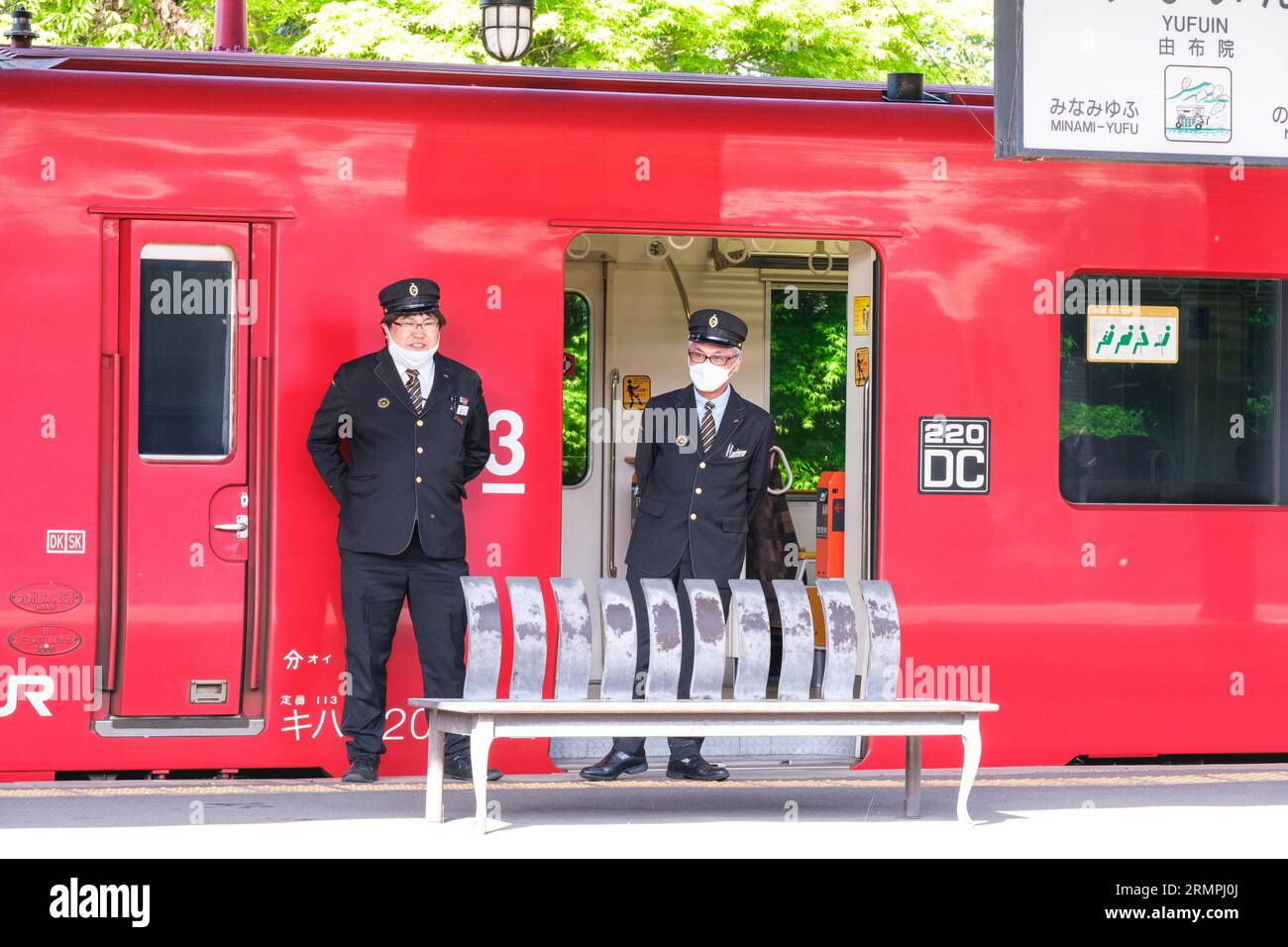 Japon, Kyushu, Yufuin. Le personnel du train attend le départ du train. Banque D'Images