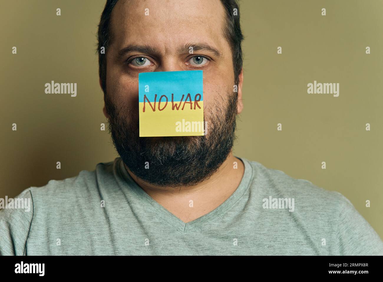 Un européen barbu avec un autocollant attaché au nez, sous la forme d'un drapeau ukrainien avec l'inscription no war Banque D'Images